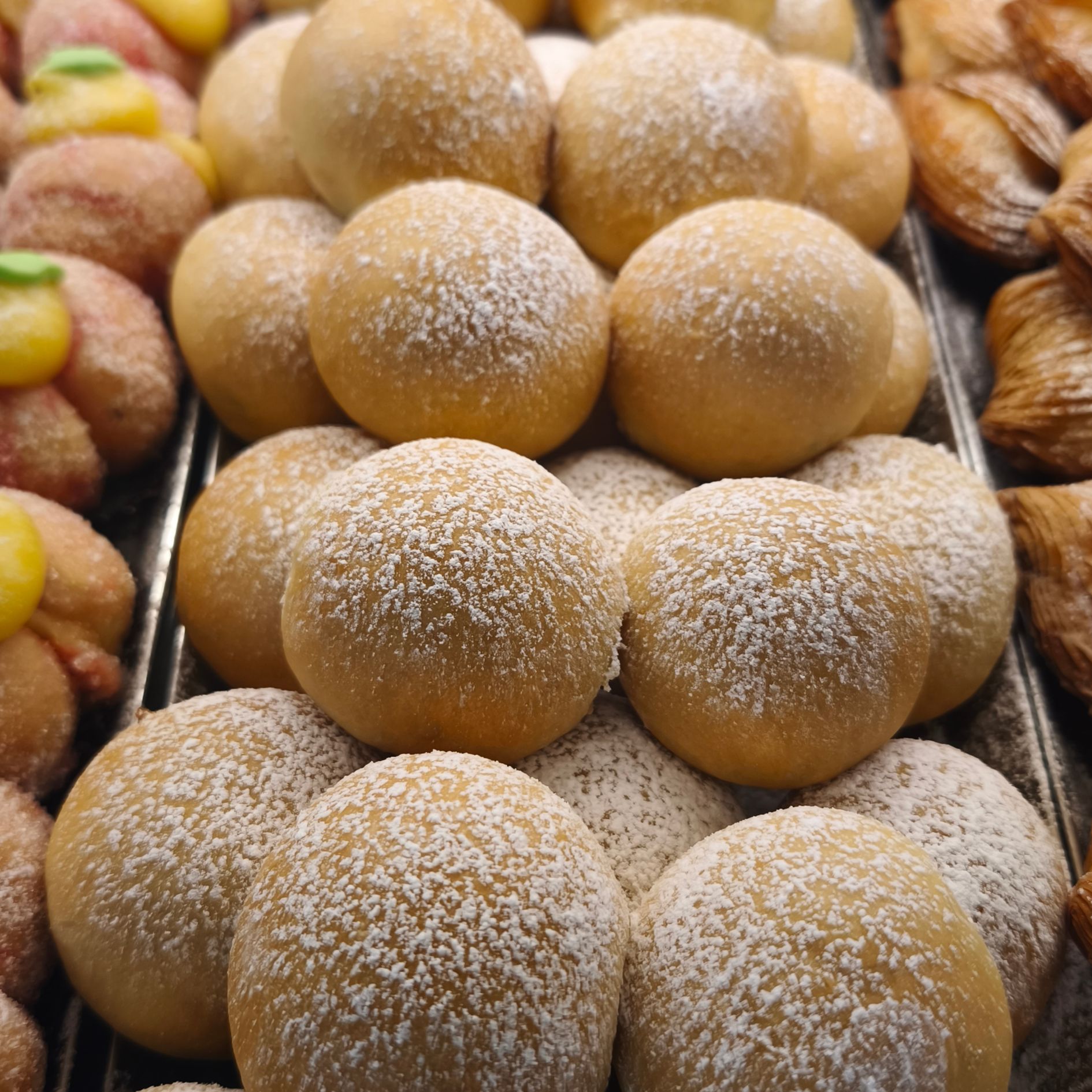 Una vetrina piena di cupcakes con lamponi e panna montata