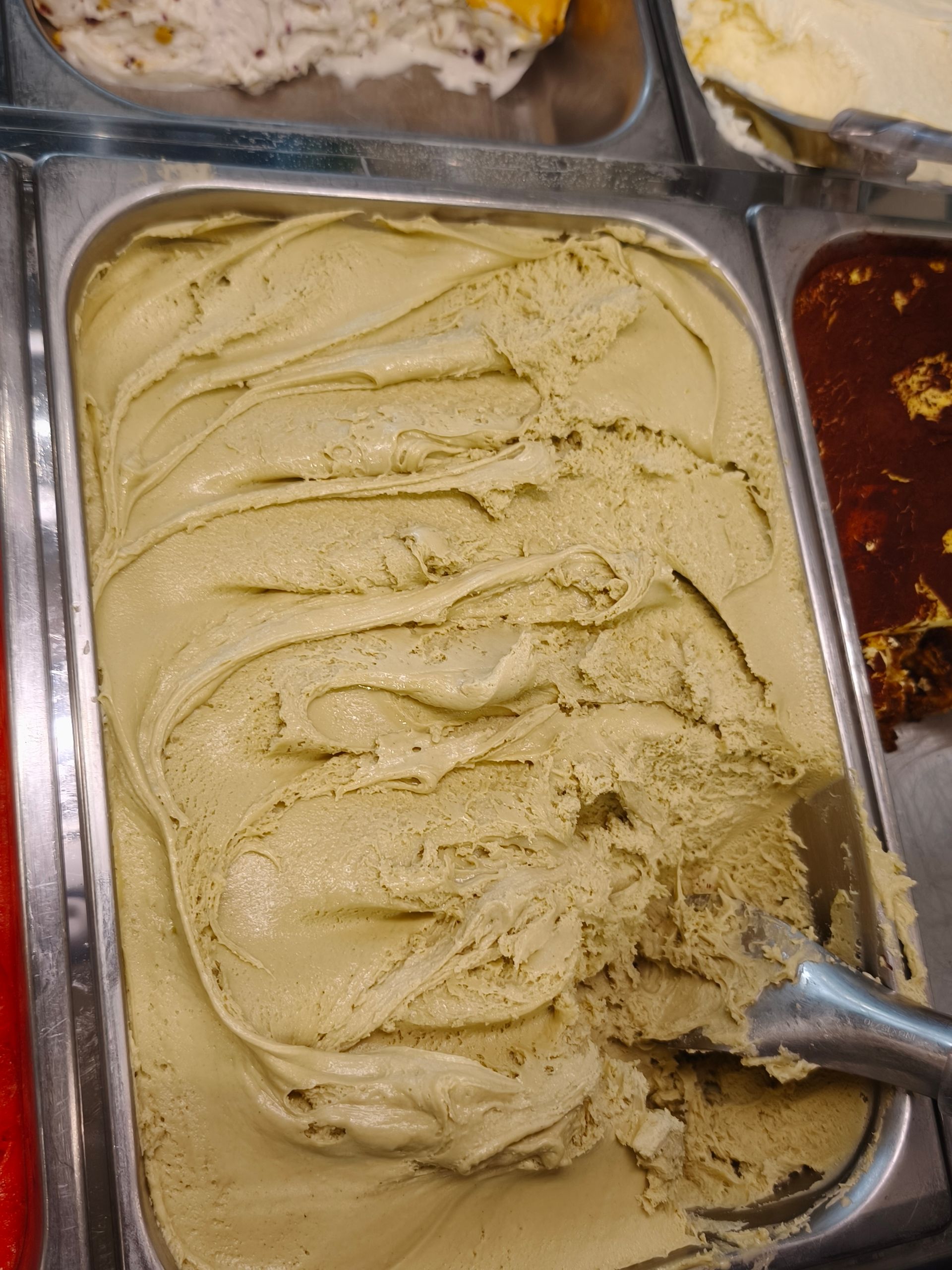 Una vaschetta di gelato con dentro un cucchiaino.
