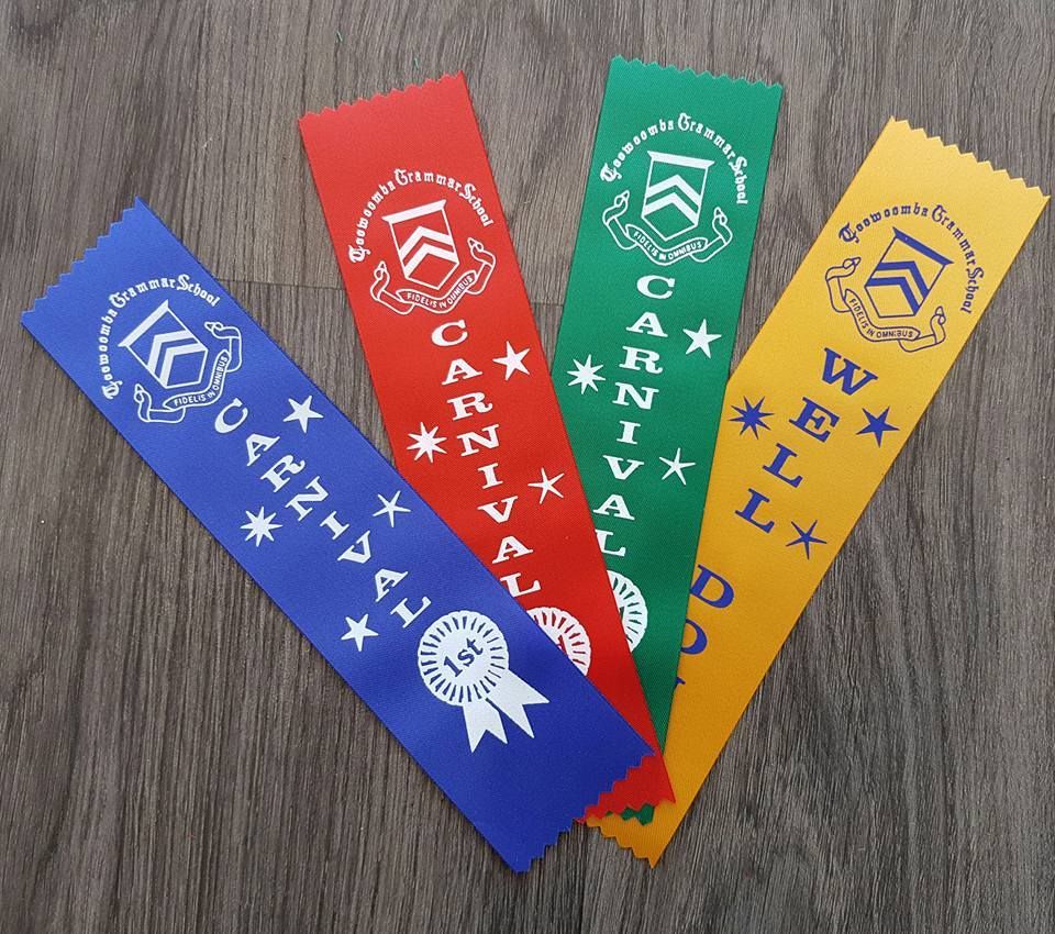 Four Carnival Ribbons Are On A Wooden Table — Sportstar Screenprinting In Newtown, QLD