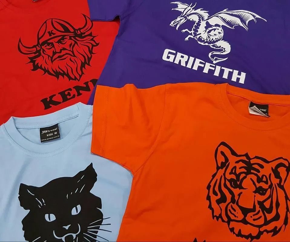 Four Colorful T-shirts Are Stacked On Top Of Each Other — Sportstar Screenprinting In Newtown, QLD