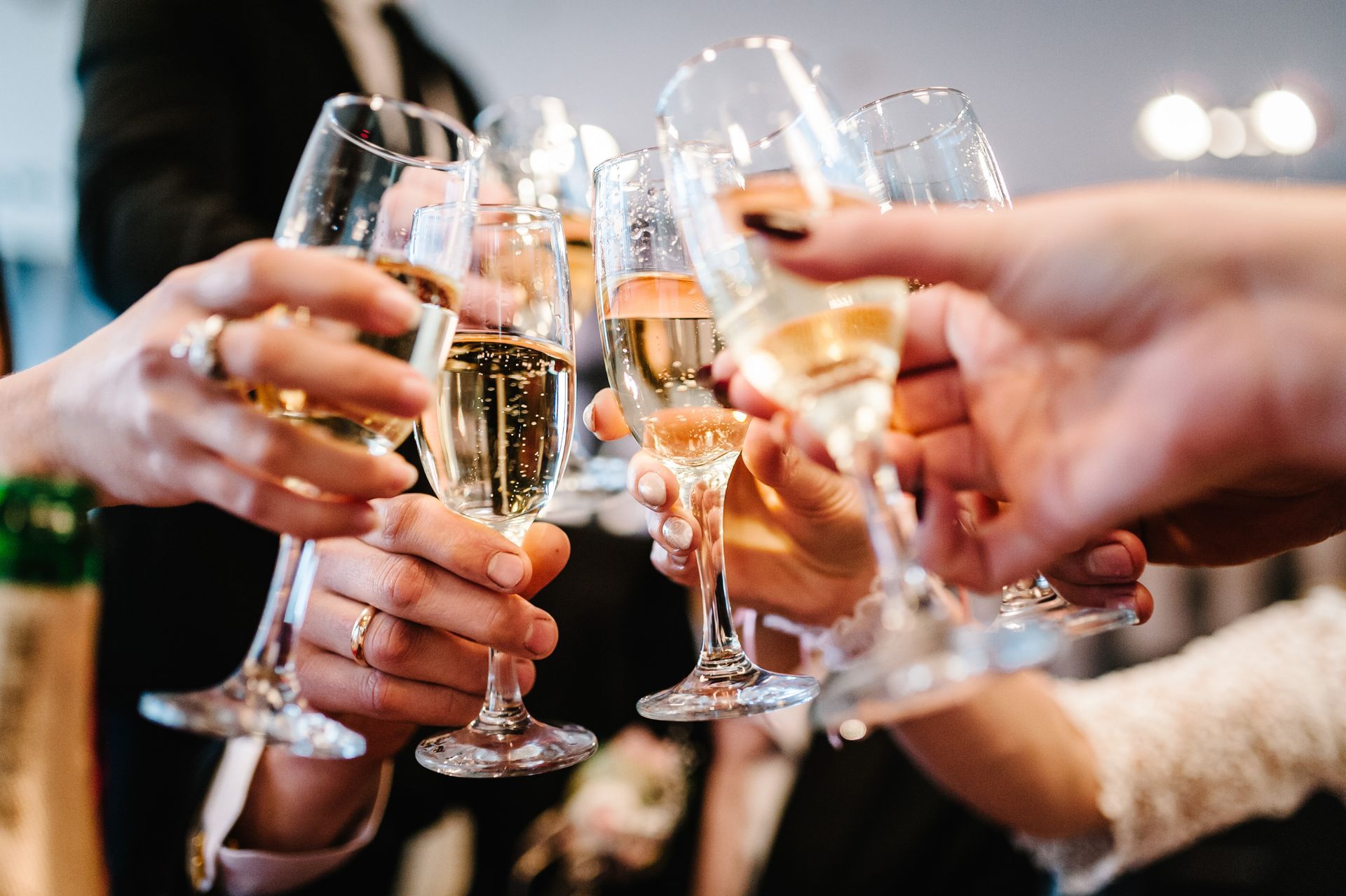 Hands raising champagne glasses in a celebratory toast at a party