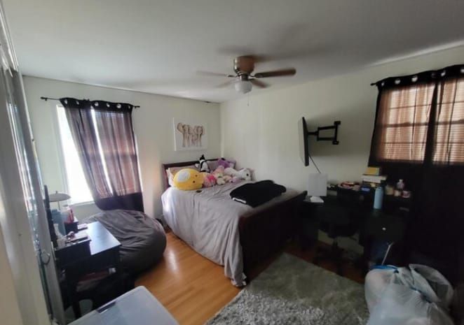 A bedroom with a bed and a ceiling fan