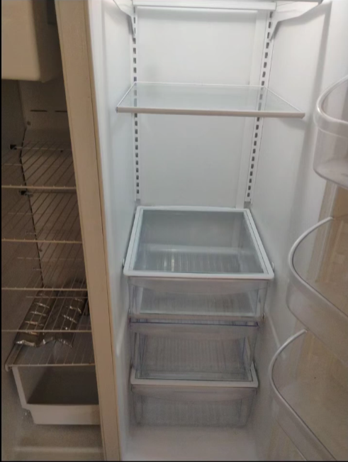The inside of an empty refrigerator with shelves and drawers