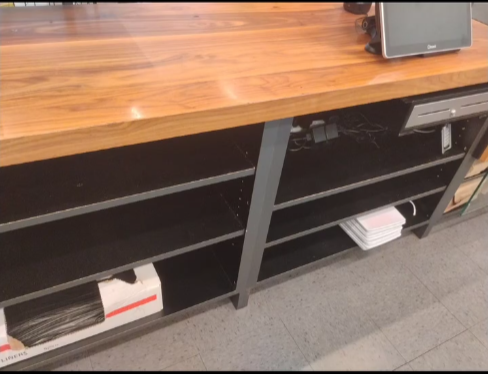 A wooden counter with a computer on top of it