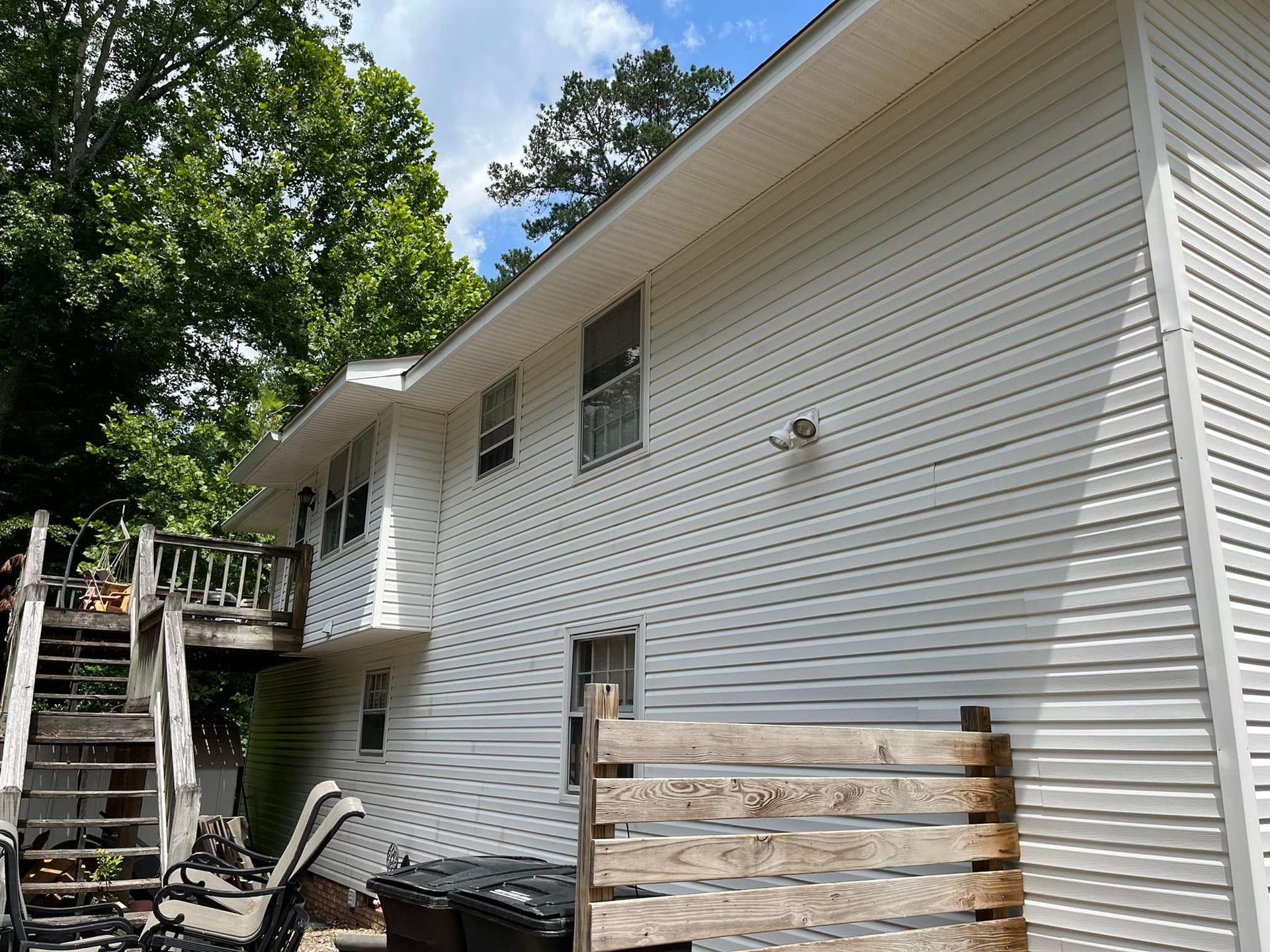 A white house with a wooden fence in front of it.
