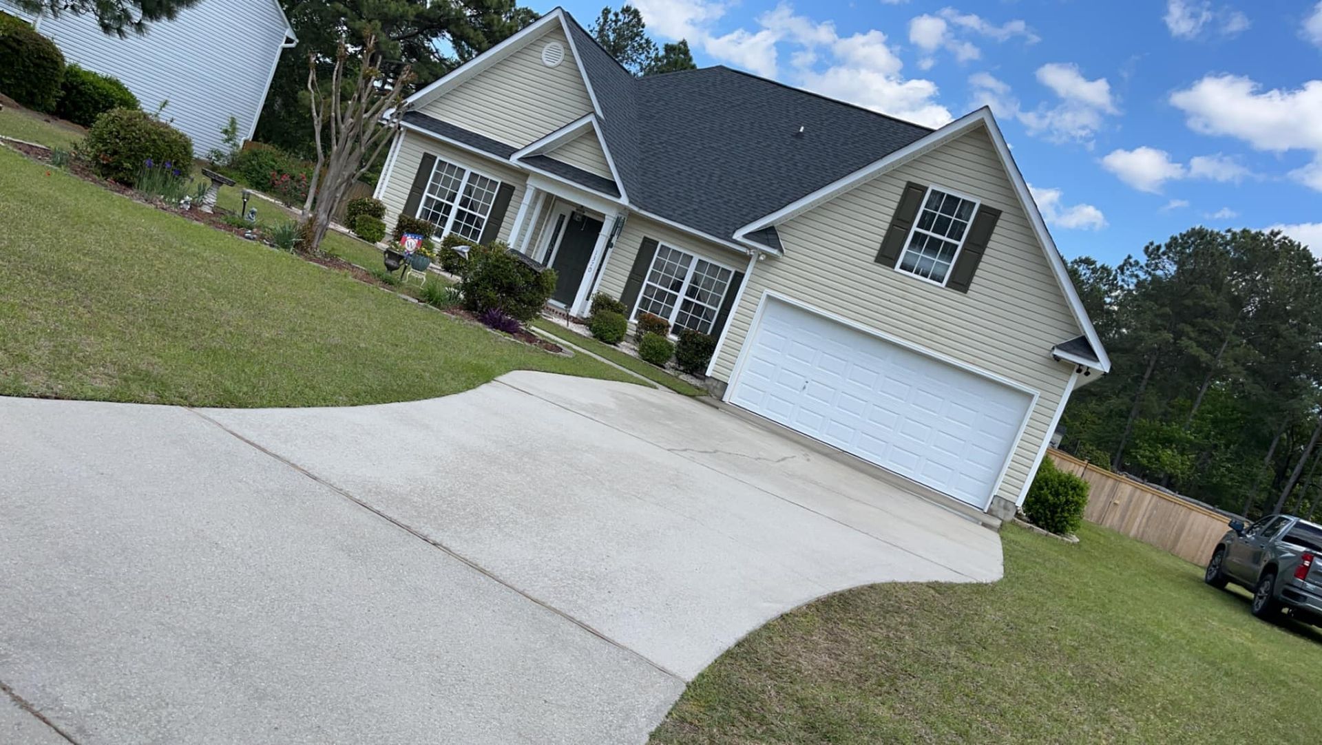 A house with a driveway and a car parked in front of it.