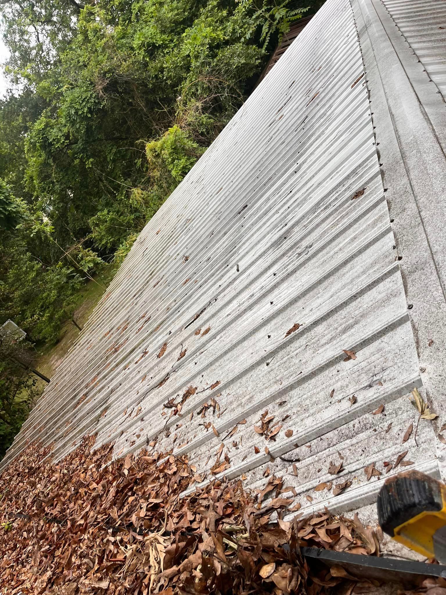 A person is cleaning a roof with a vacuum cleaner.