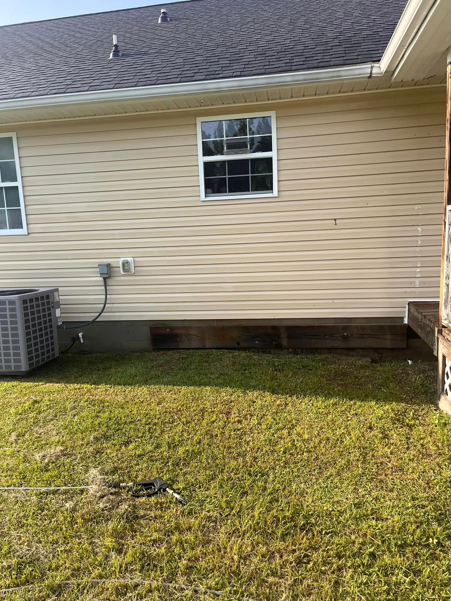 The backyard of a house with a window and air conditioner.