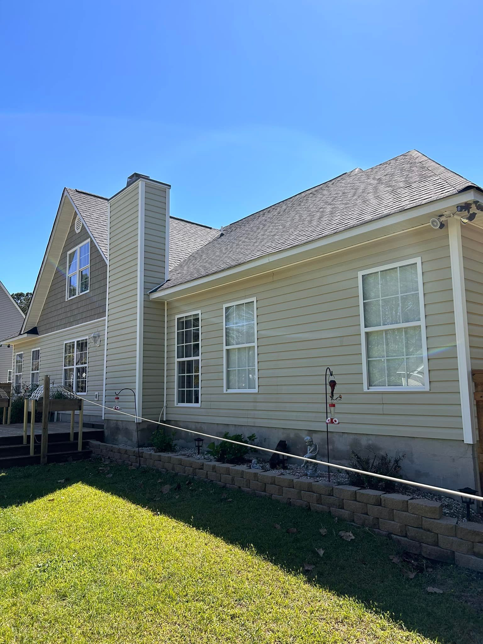 A large house with a lot of windows is sitting on top of a lush green lawn.