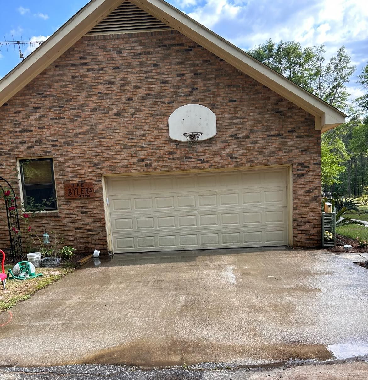 A brick house with a white garage door and a basketball hoop on the side