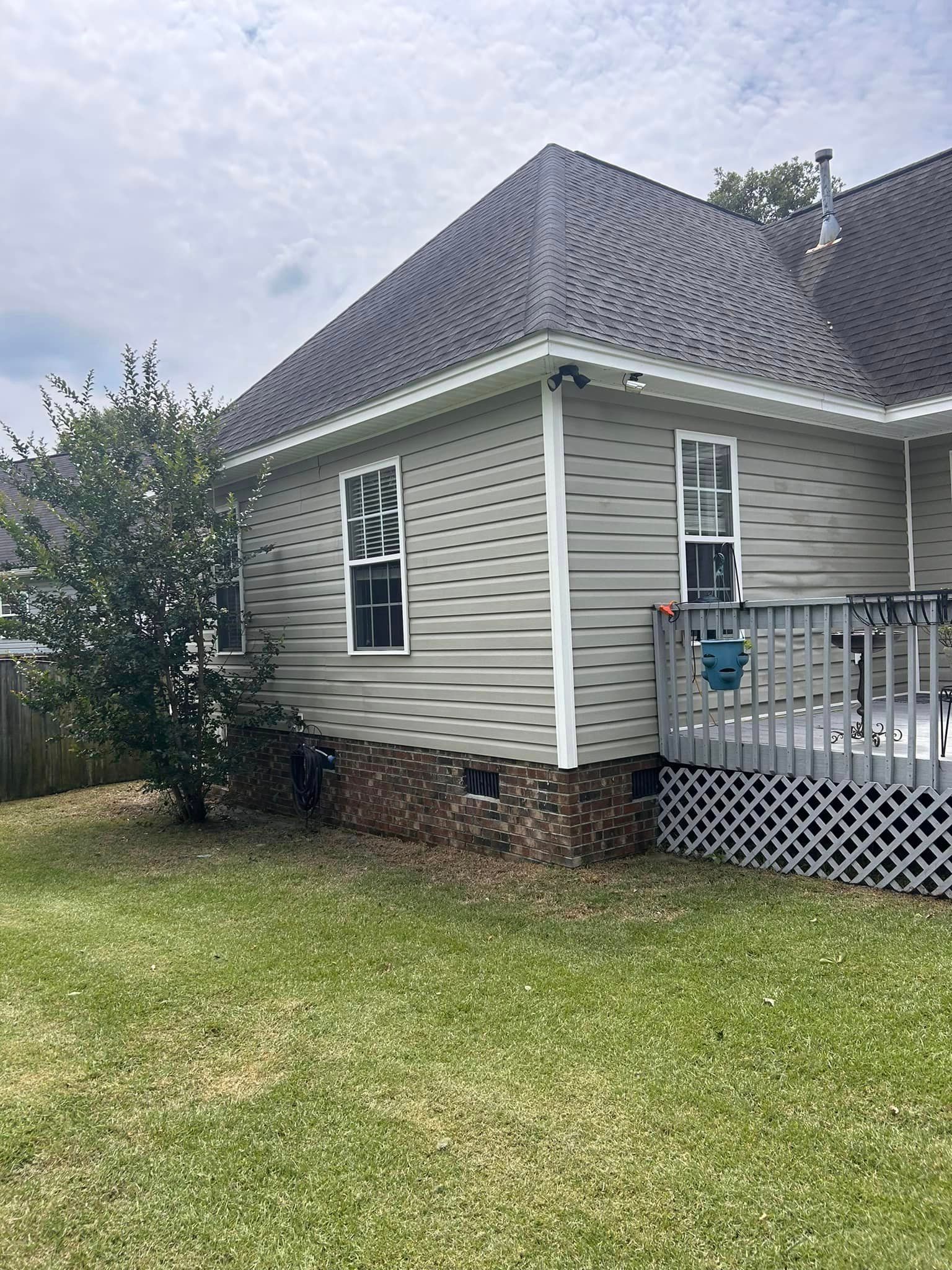 The back of a house with a deck and a lot of windows.