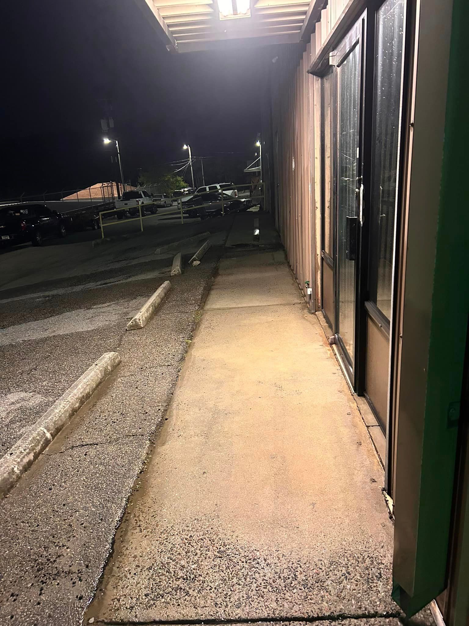 A concrete walkway leading to a building at night.