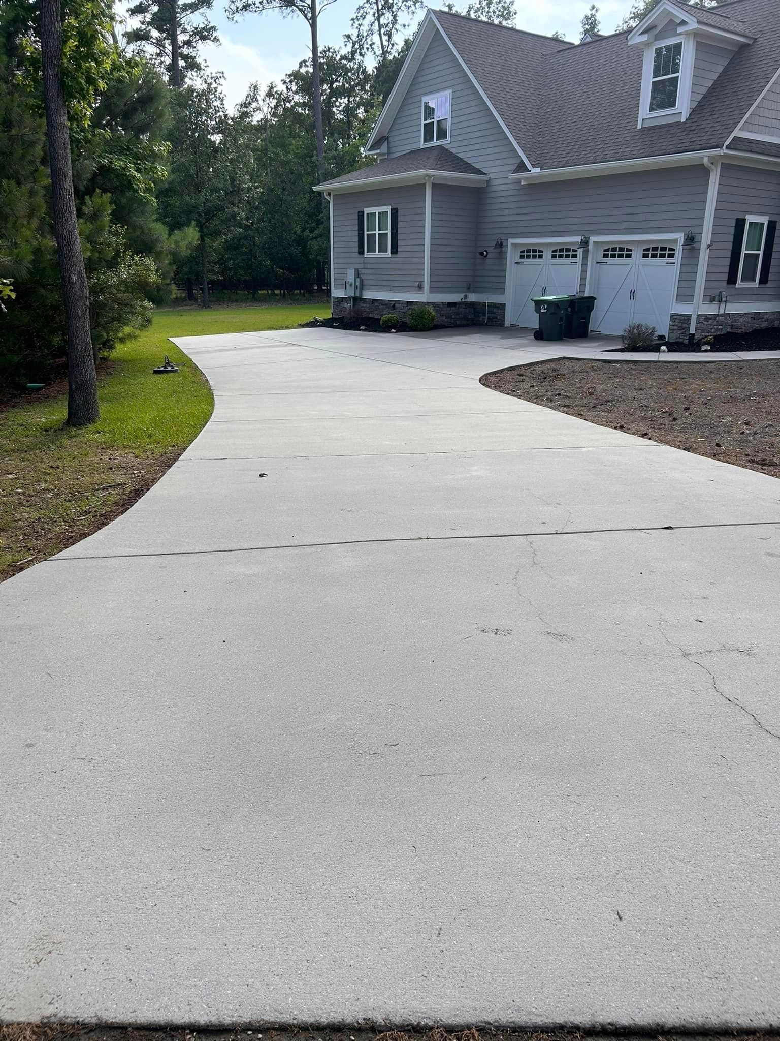 A large house with a concrete driveway leading to it