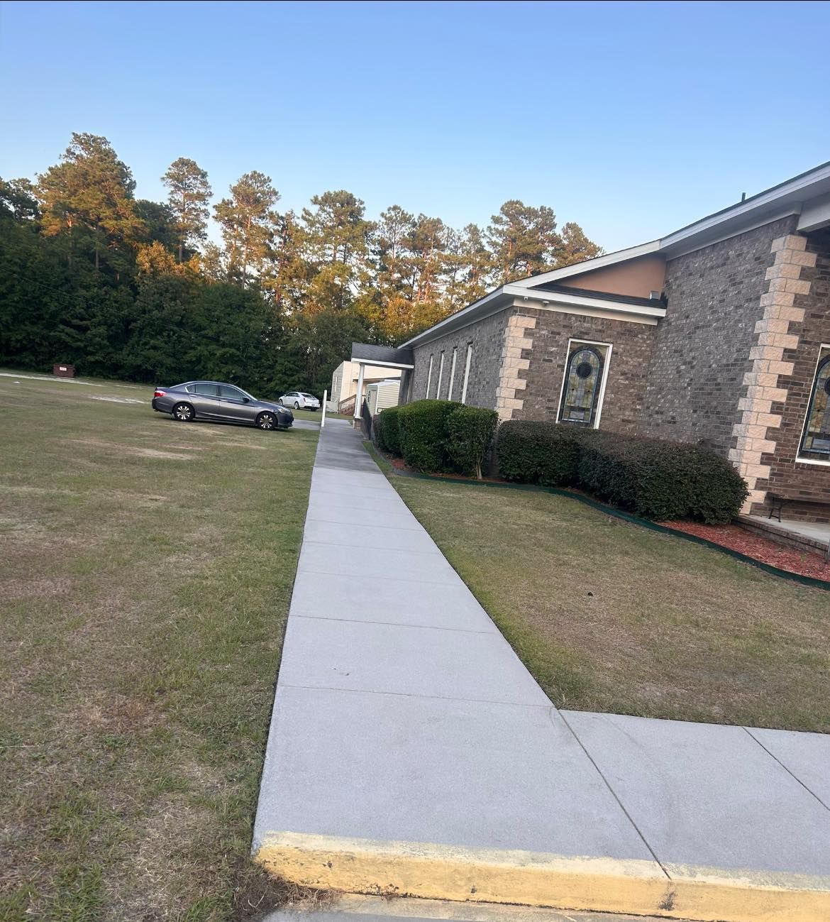 A brick building with a sidewalk leading to it