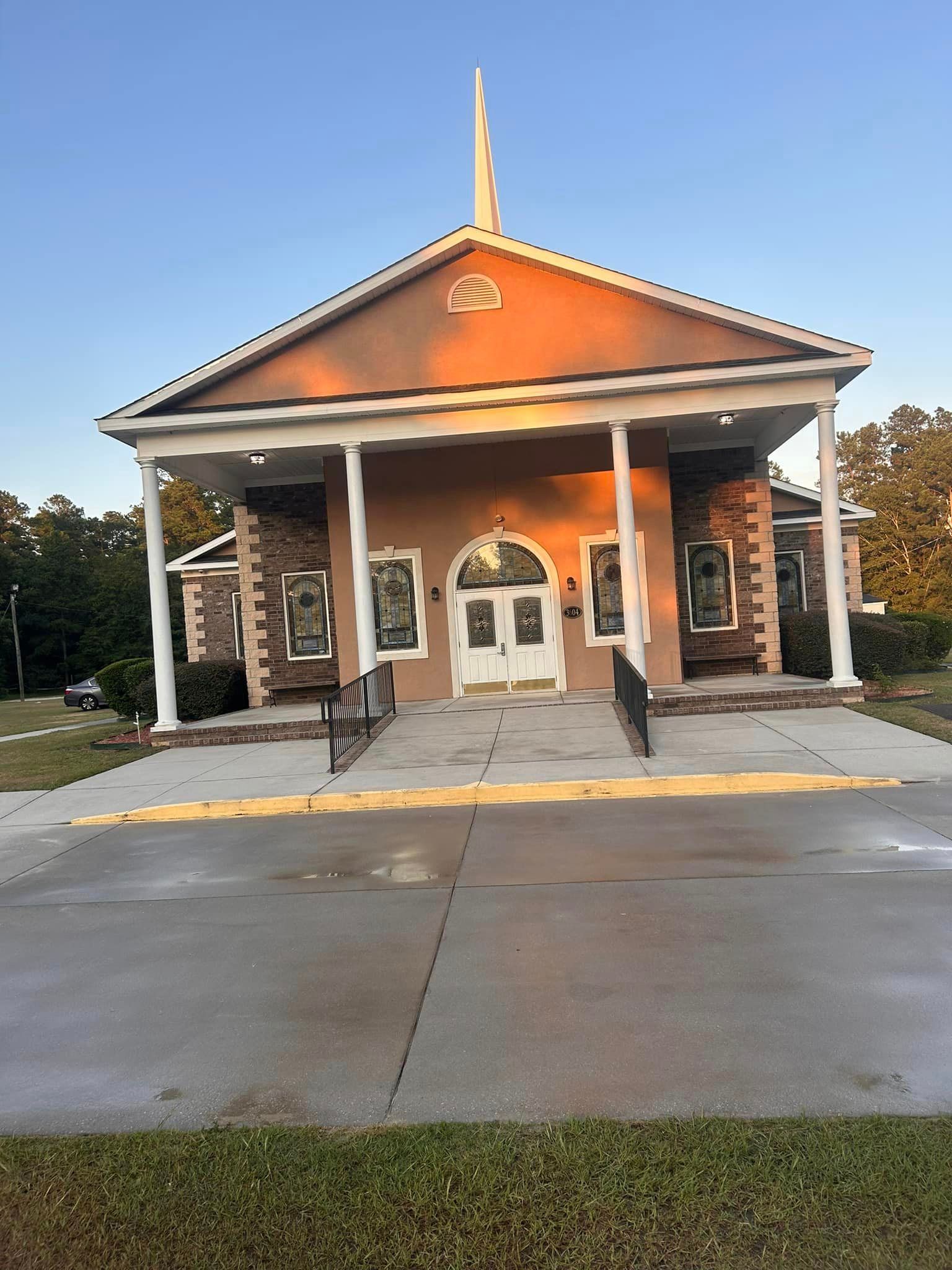 A church with a steeple and a ramp in front of it