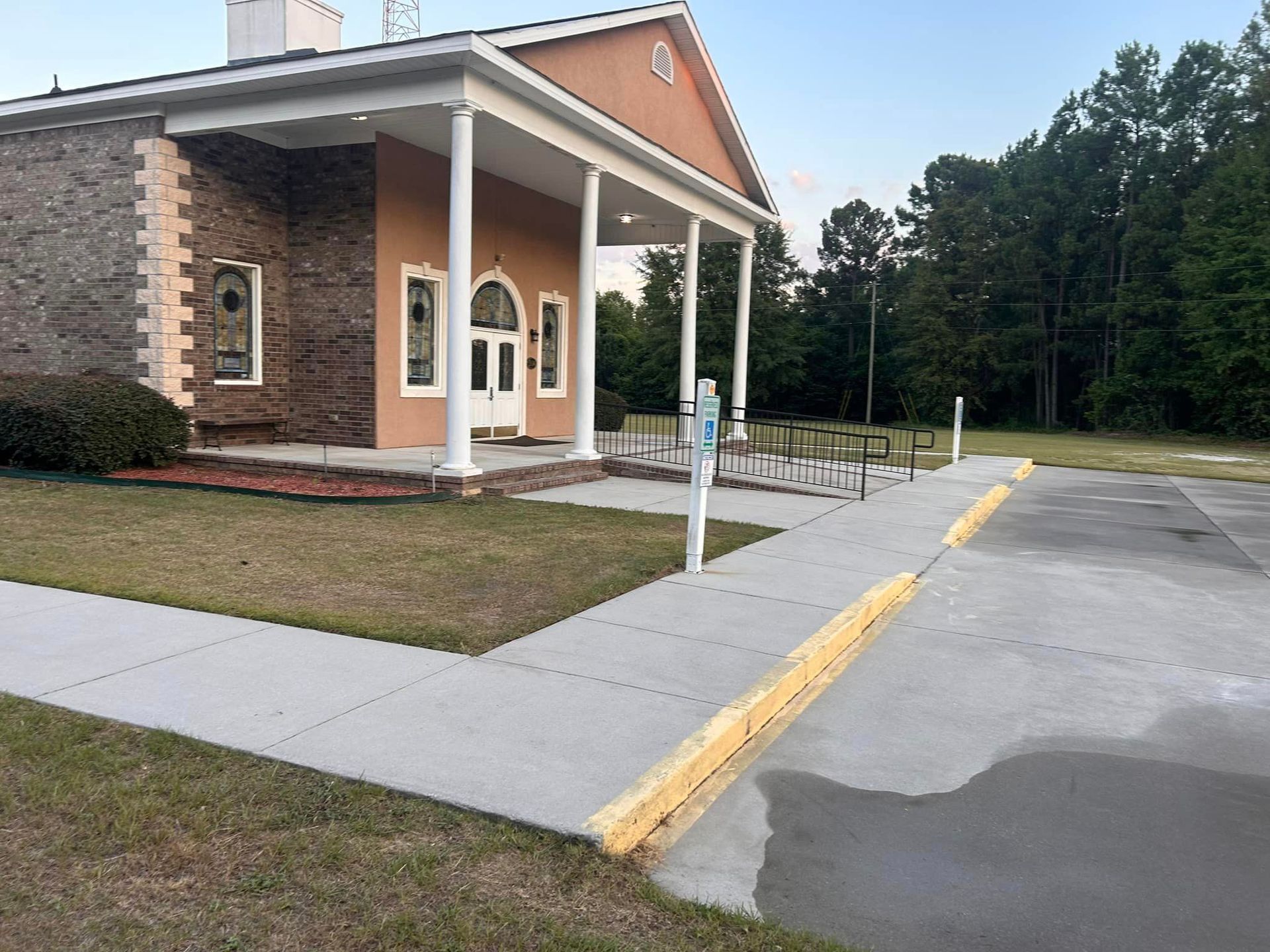 A building with a porch and a sidewalk in front of it