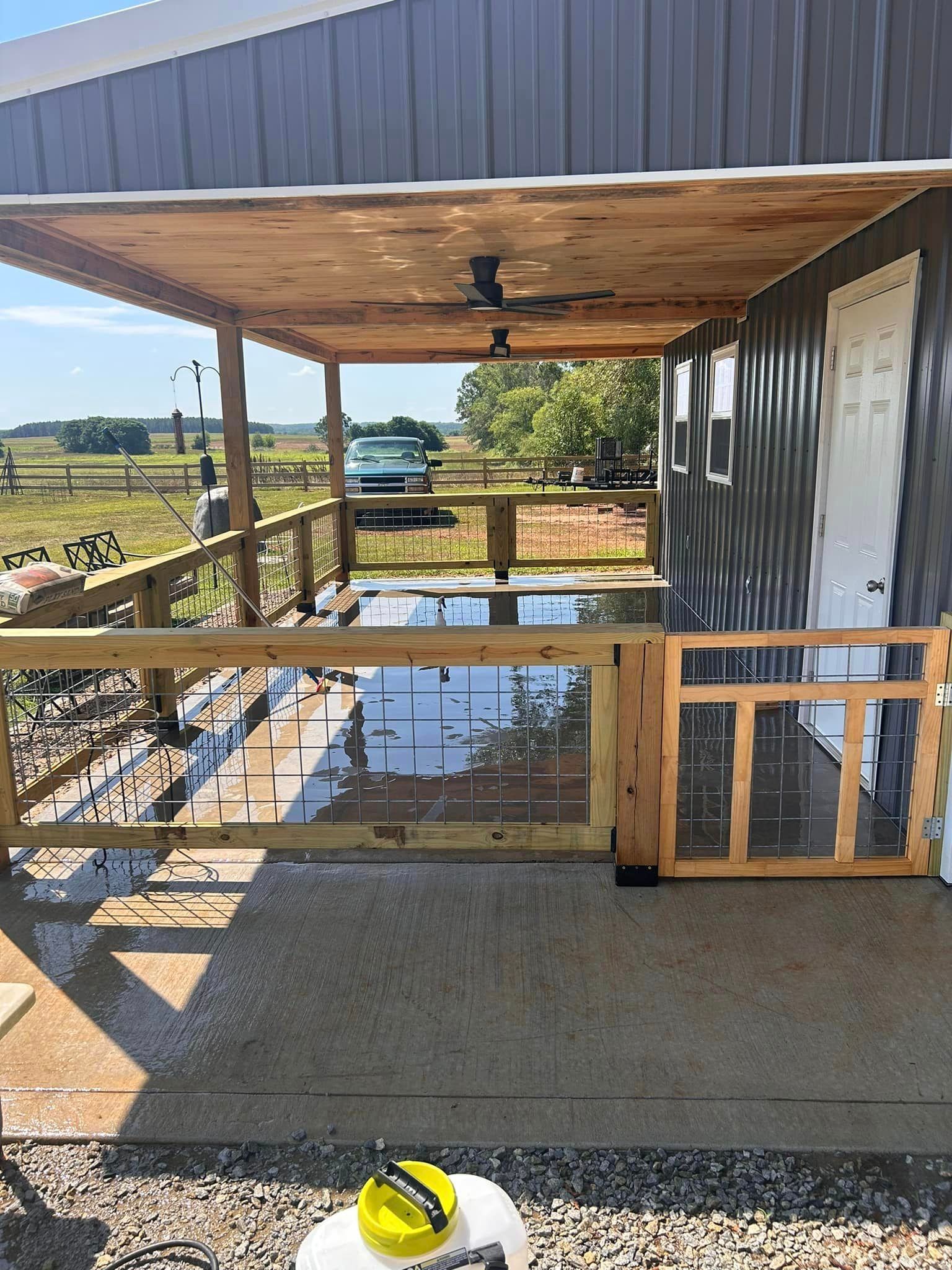 A porch with a wooden fence and a ceiling fan.