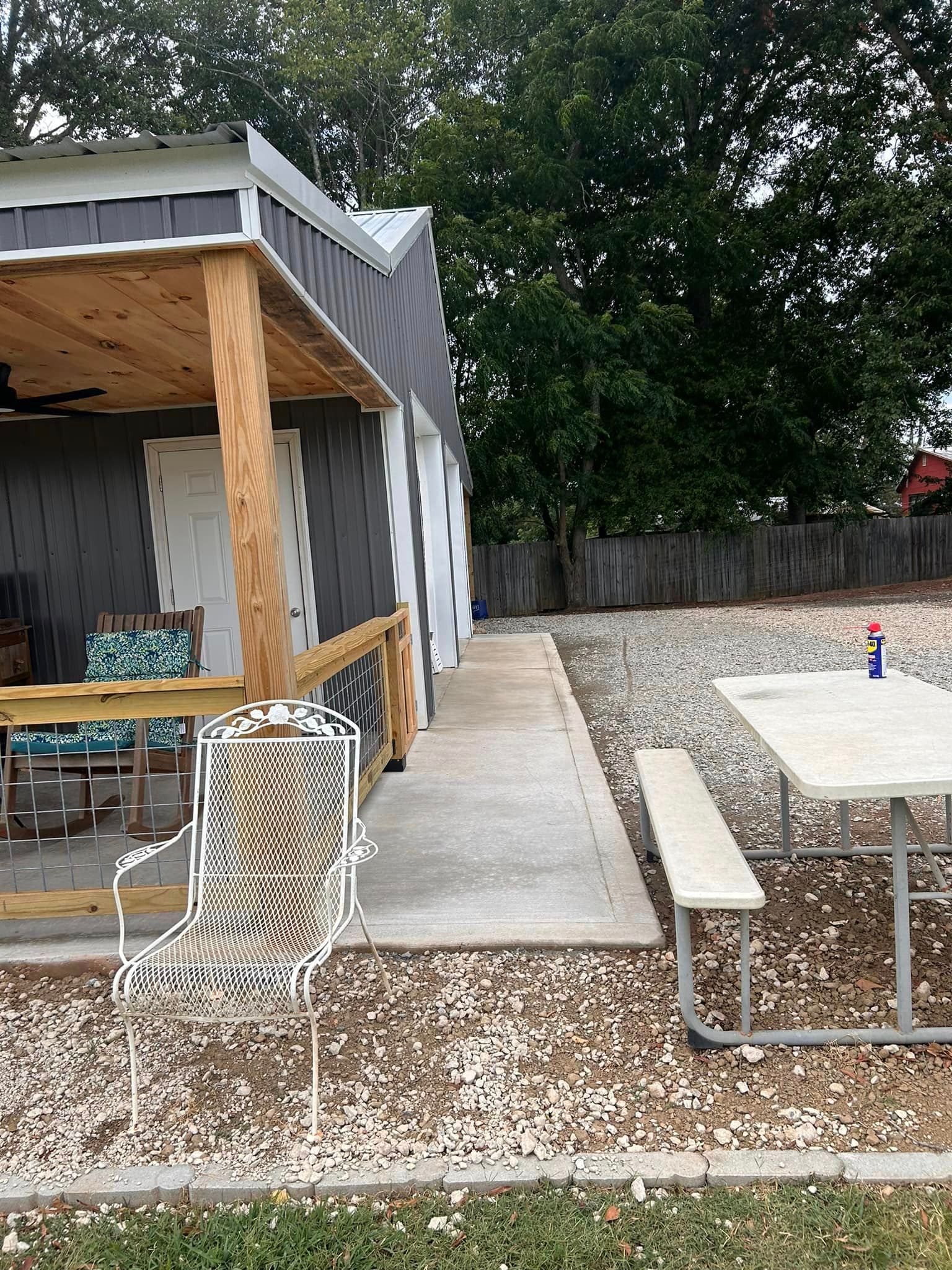 There is a picnic table and chairs on the side of the house.