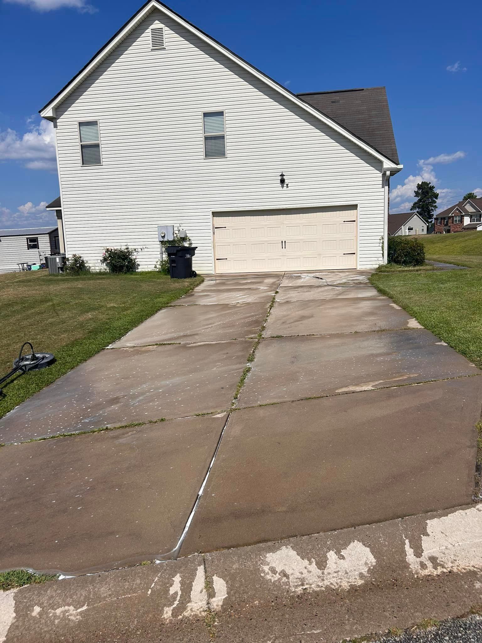 A white house with a concrete driveway in front of it