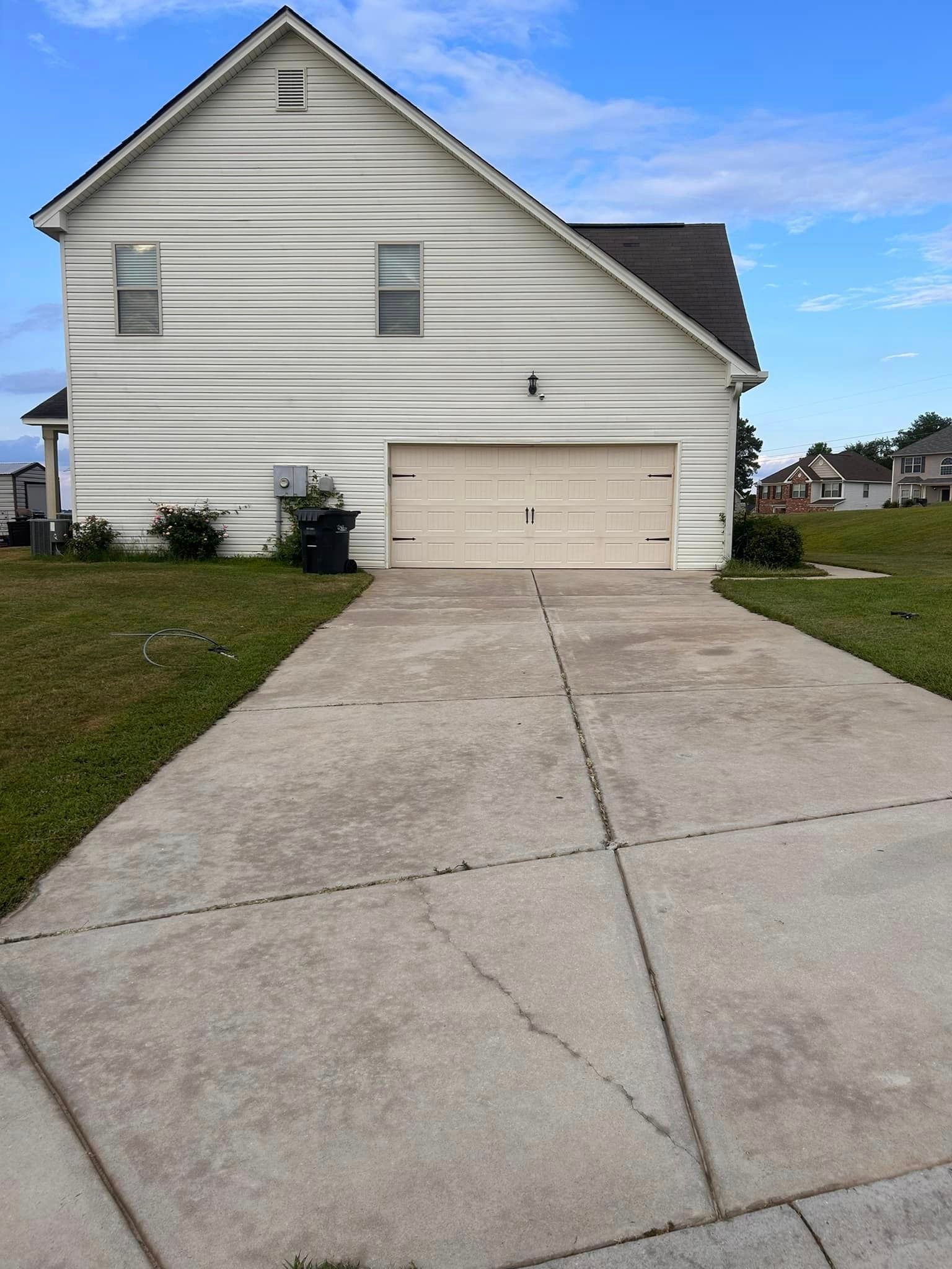 A white house with a concrete driveway leading to it