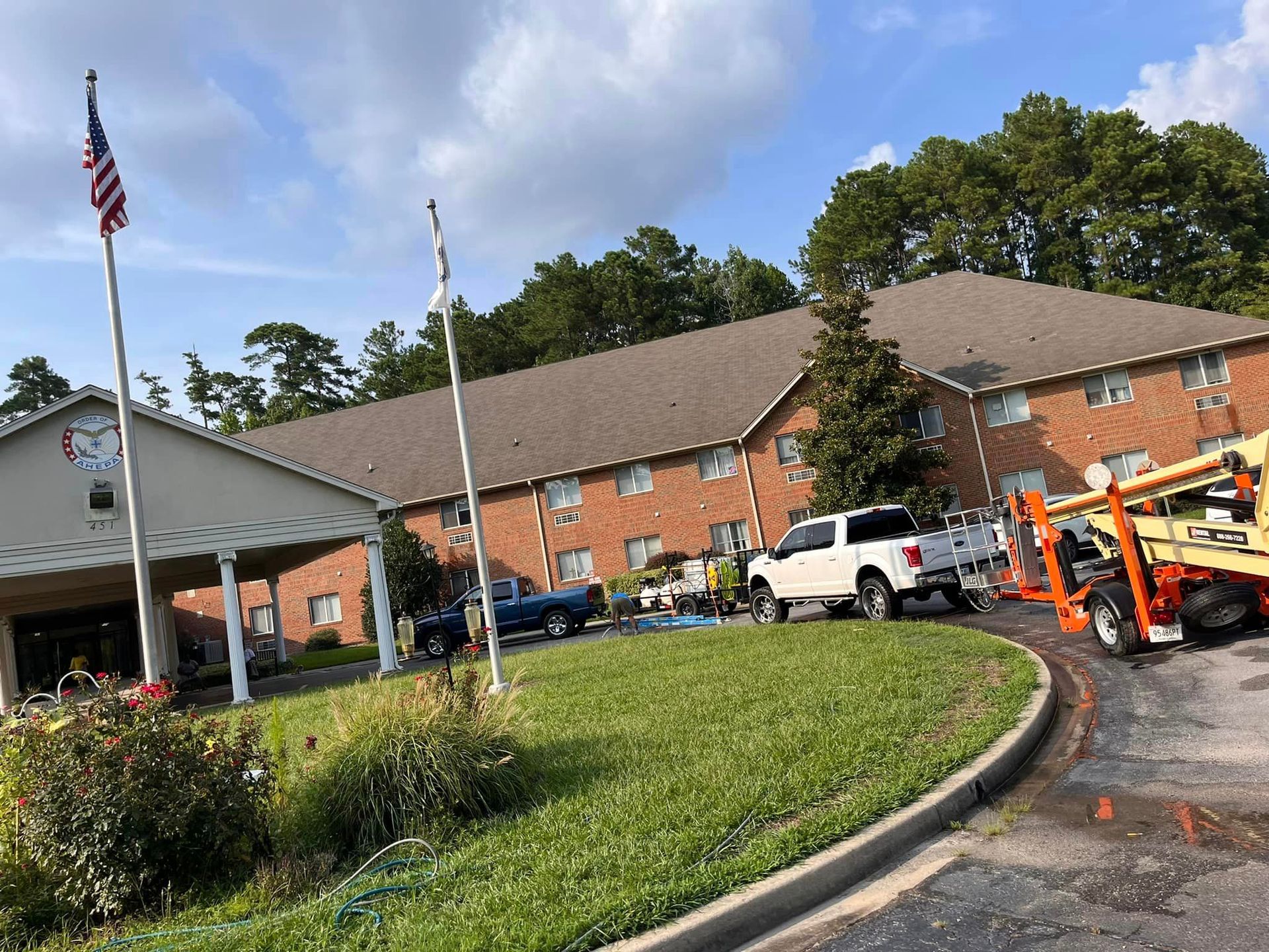 A large brick building with a lot of cars parked in front of it.