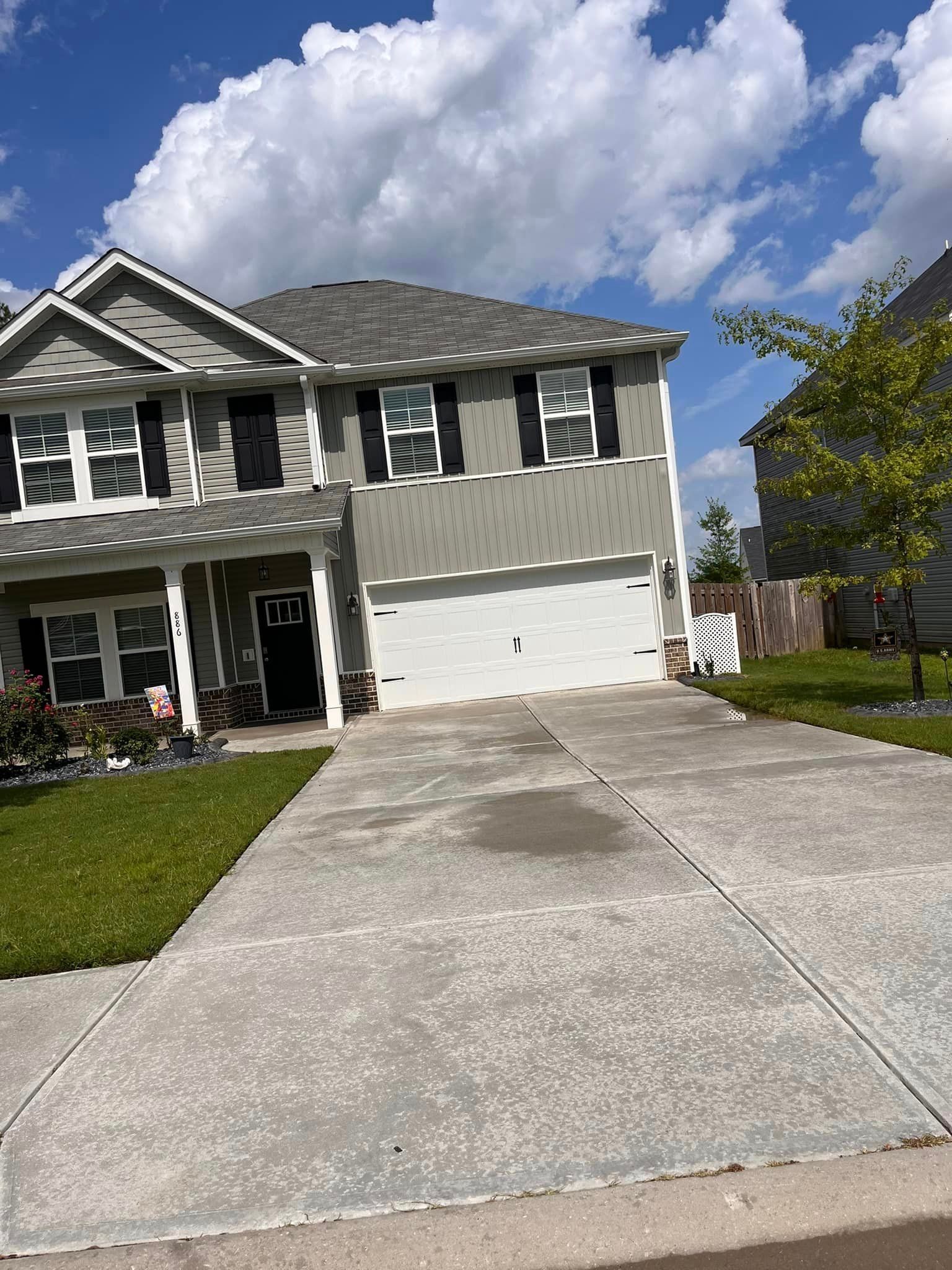 A large house with a concrete driveway in front of it.