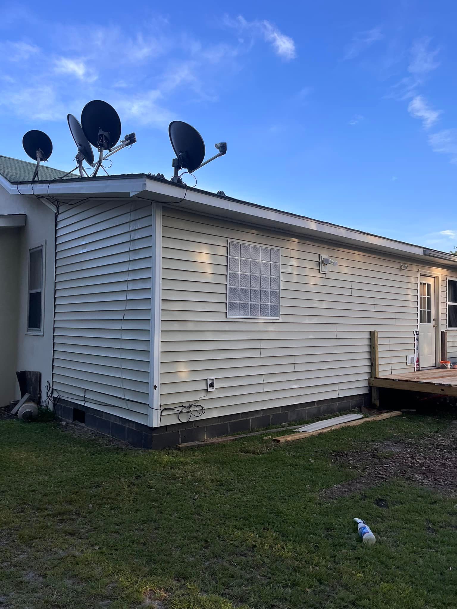 A white house with satellite dishes on the roof