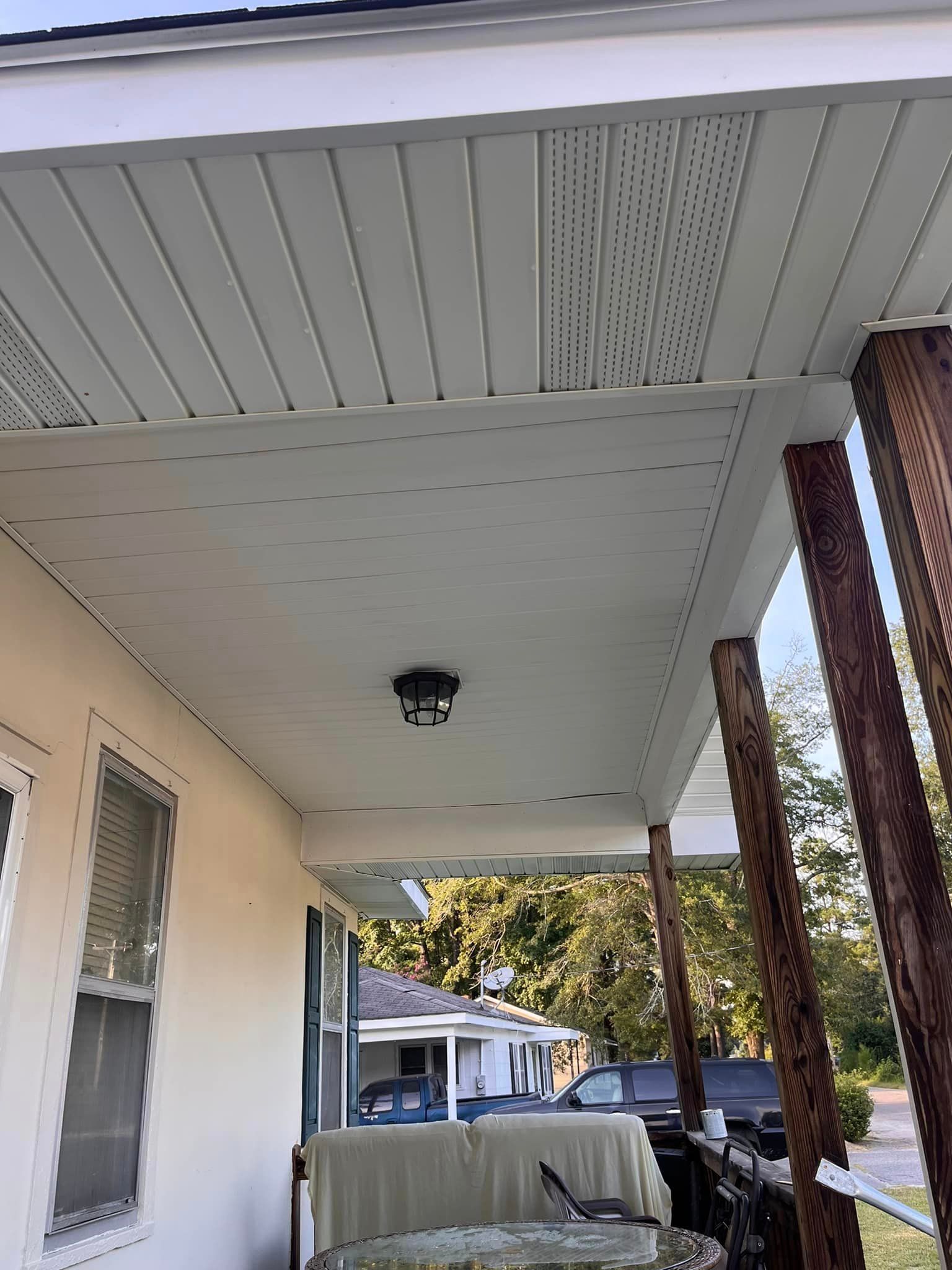 A porch with a white ceiling and a light on it.