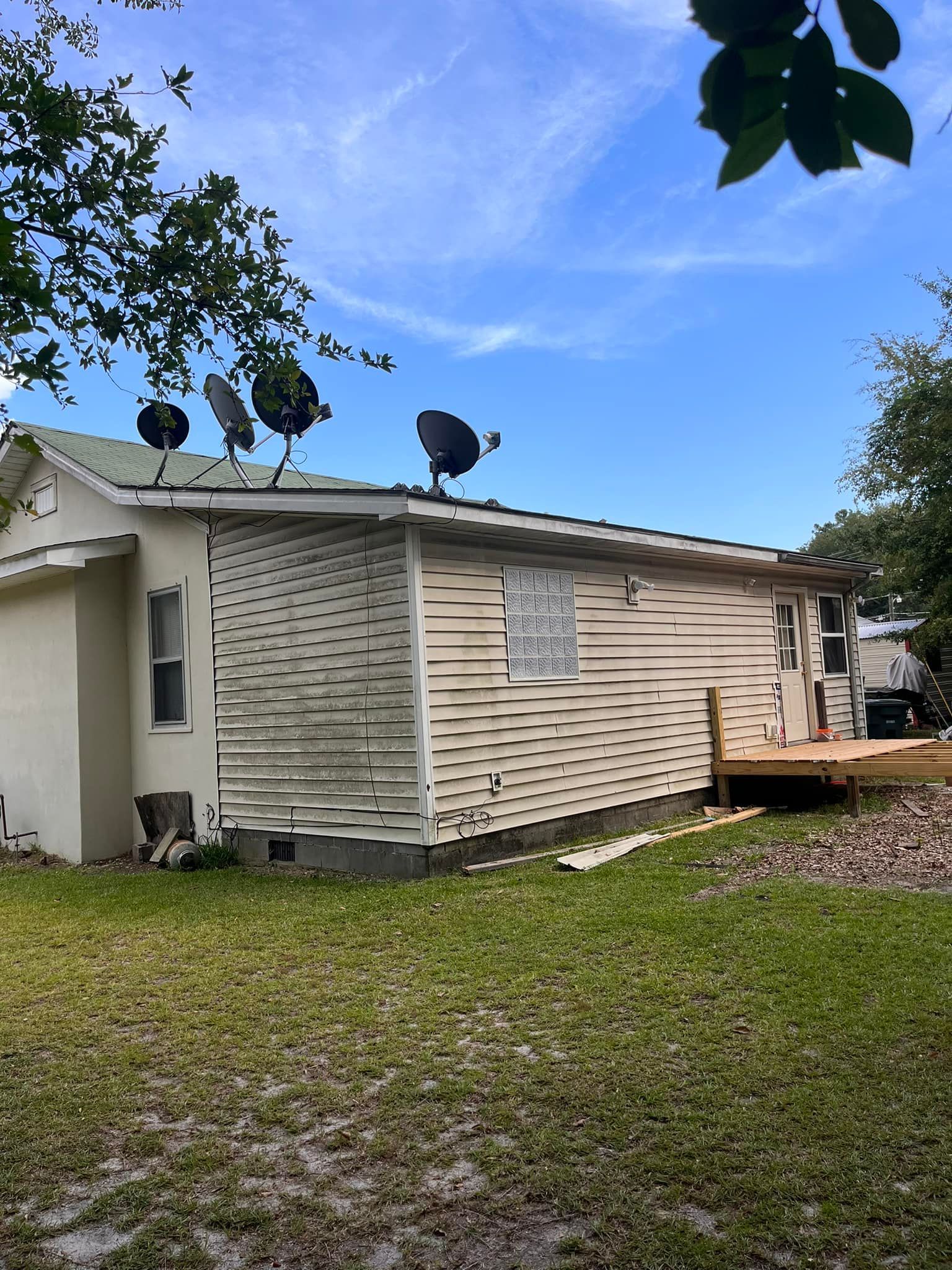 A white house with satellite dishes on the roof