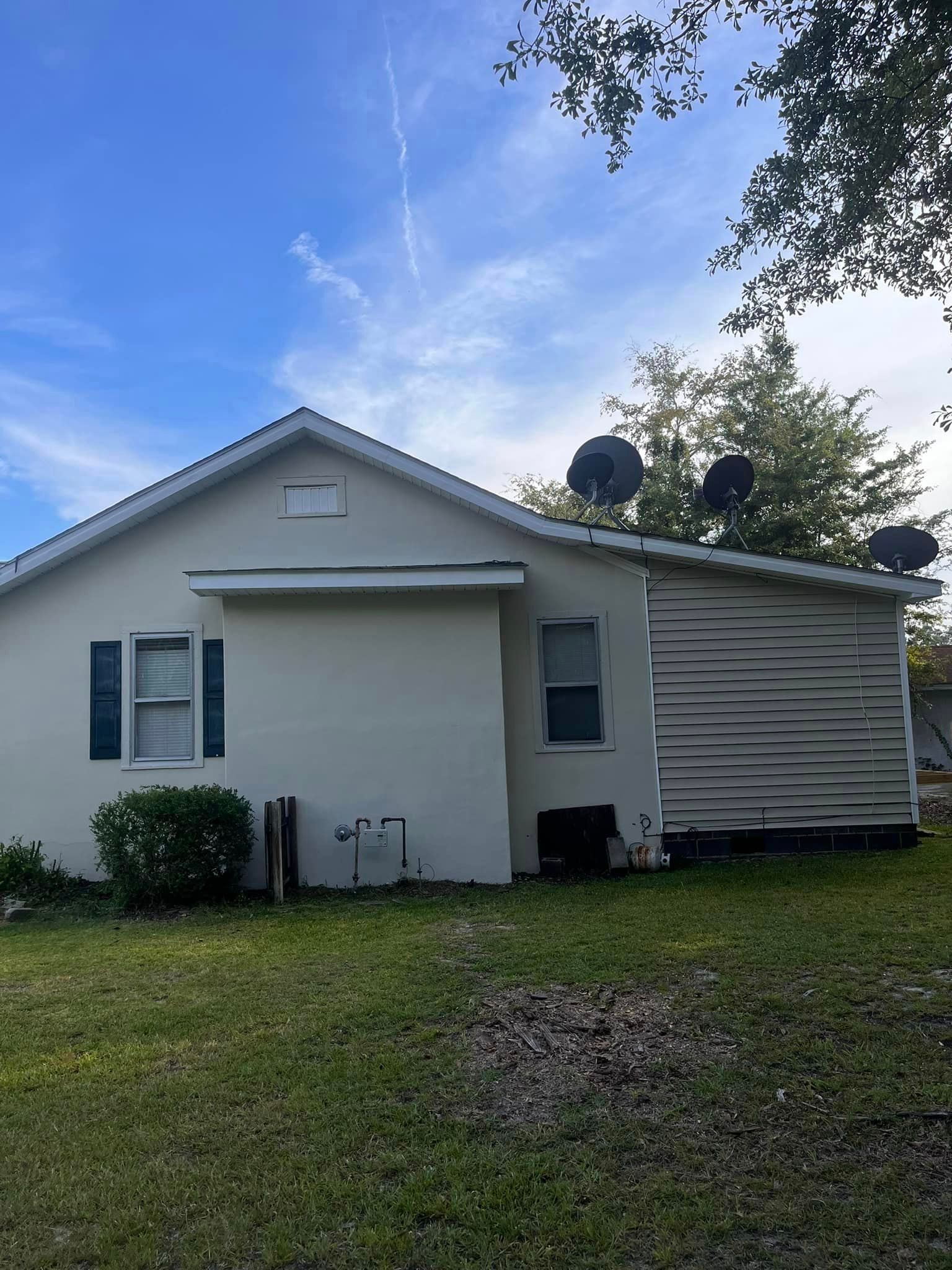 A white house with satellite dishes on the roof