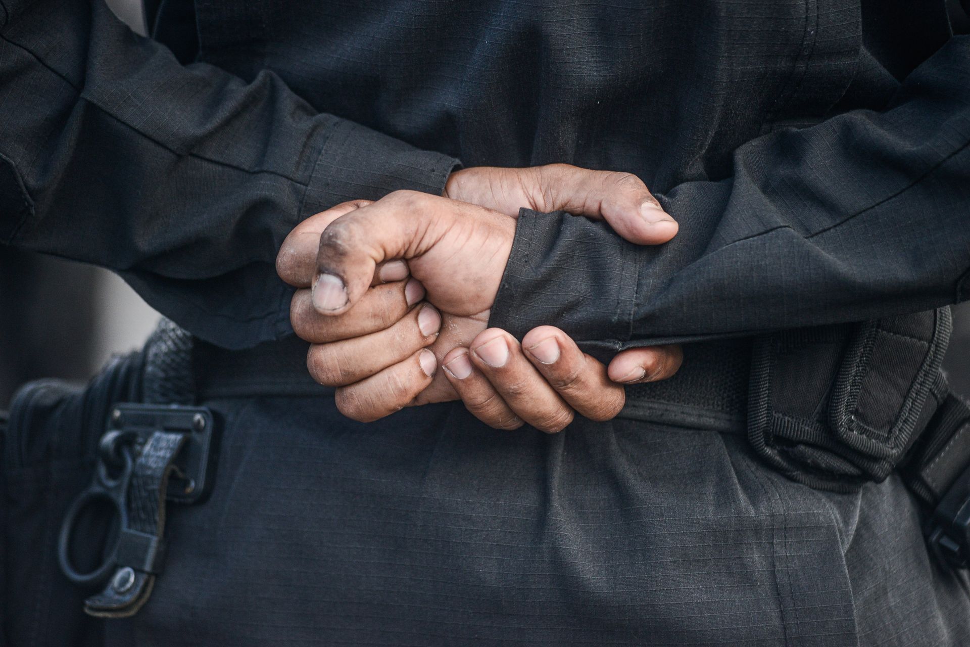 A close up of a person's hands behind their back.