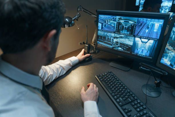 A man is sitting at a desk looking at a computer screen.