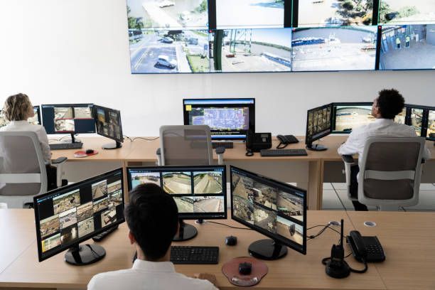 A group of people are sitting at desks in front of monitors.