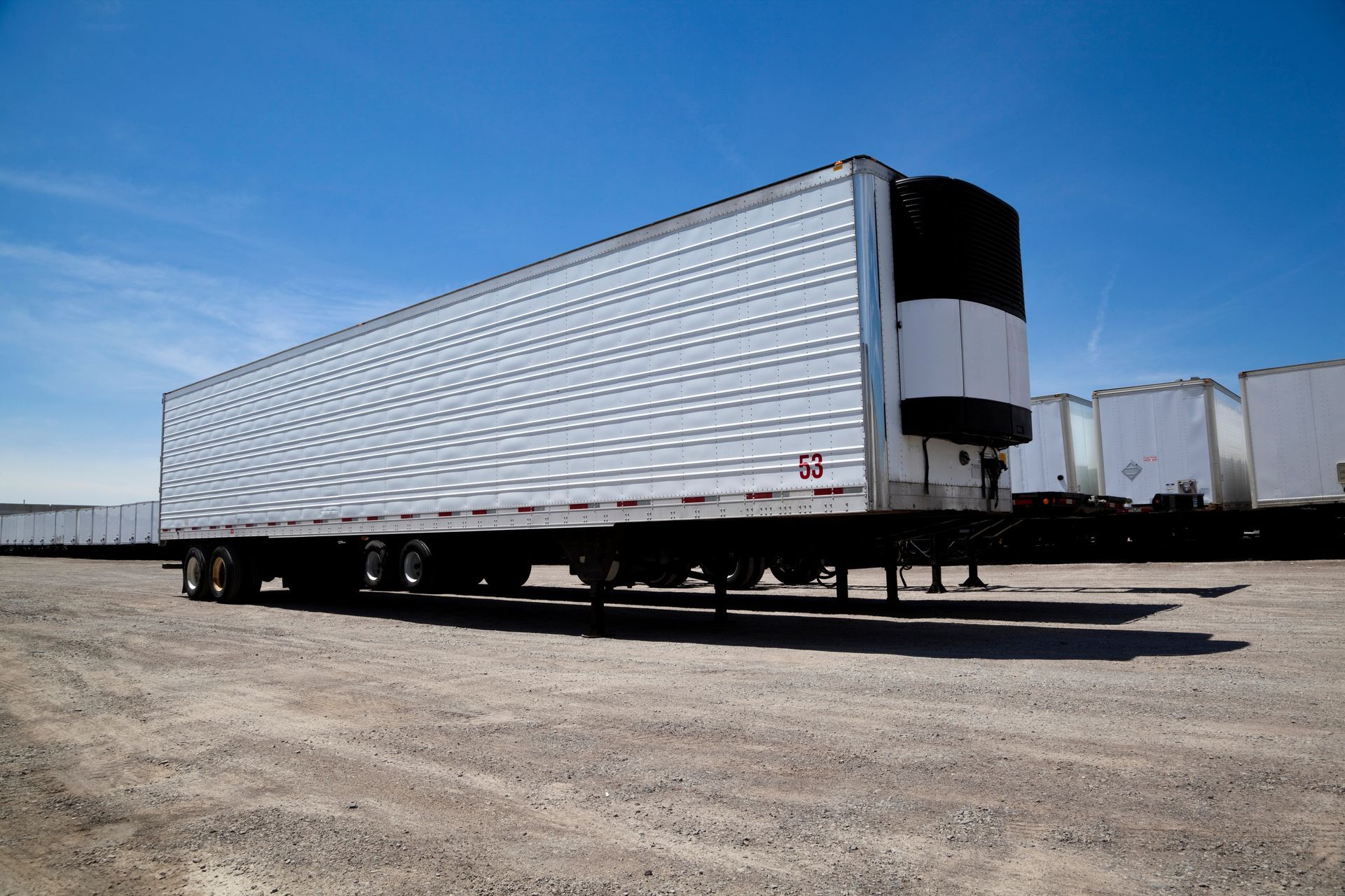 Front view of a small white cargo trailer parked on a neighborhood street