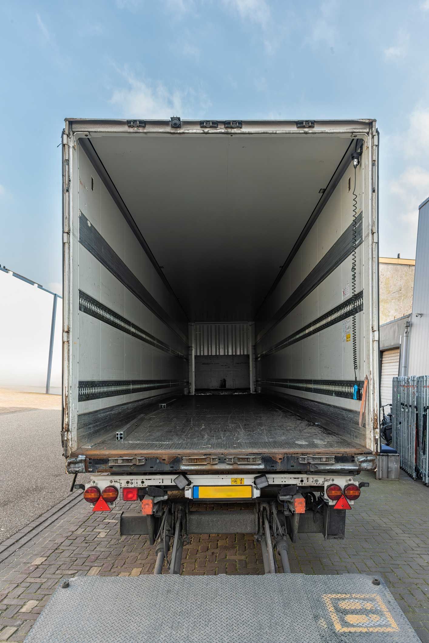 A rear view of a refrigerated semi-trailer where the loading space is clearly visible
