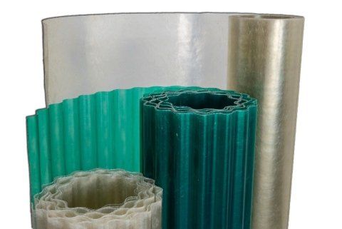 Vari rotoli di pannelli in fibra di vetro ondulati e piani nelle tonalità del verde e del trasparente.