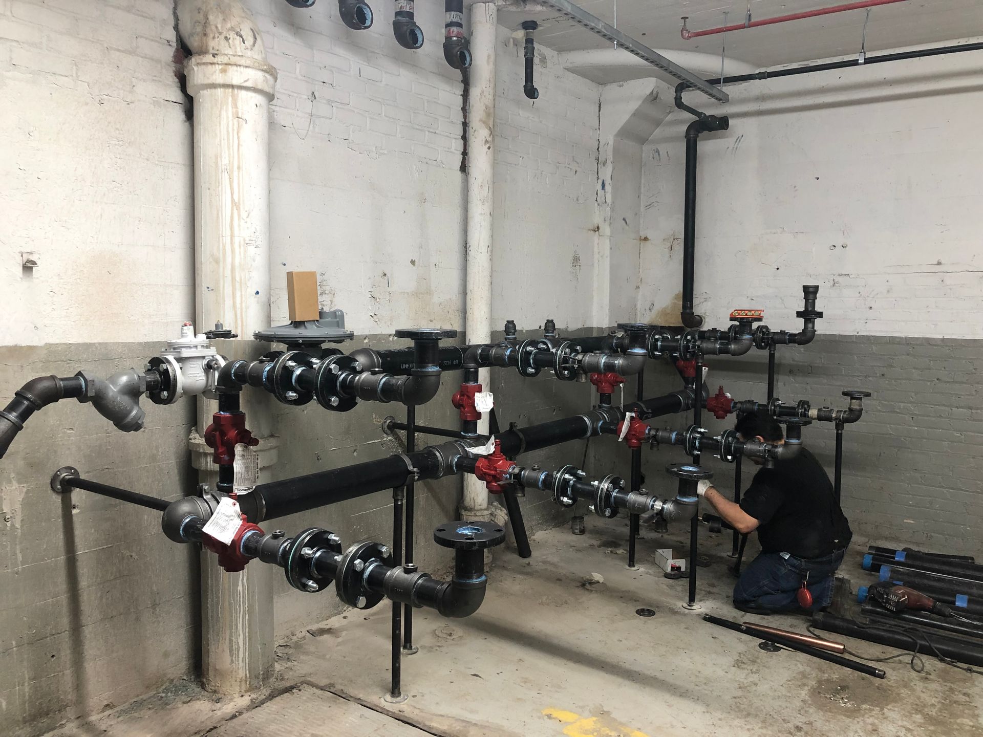 A man is working on a sprinkler in a garden.