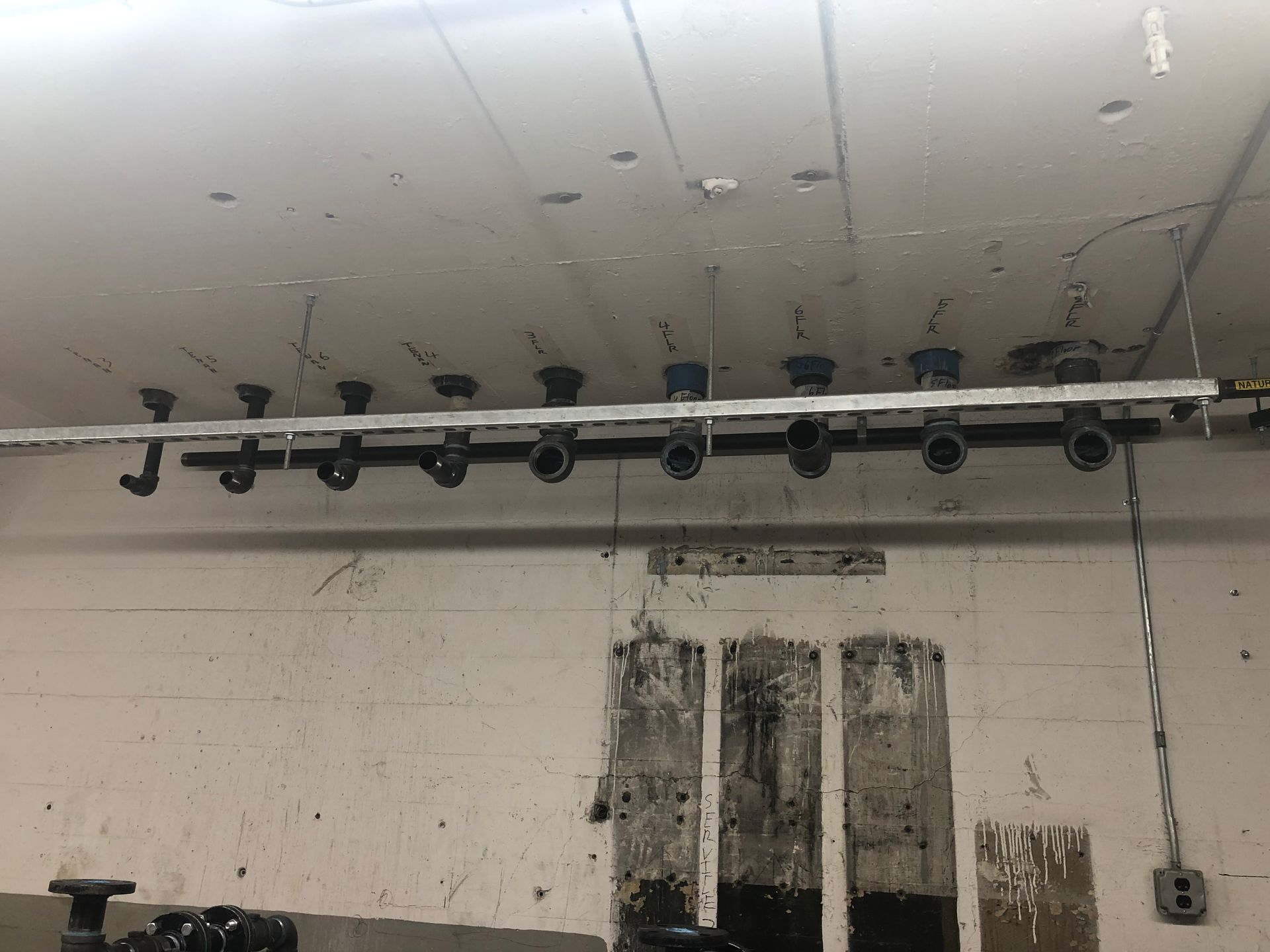 A row of pipes hanging from the ceiling of a building.