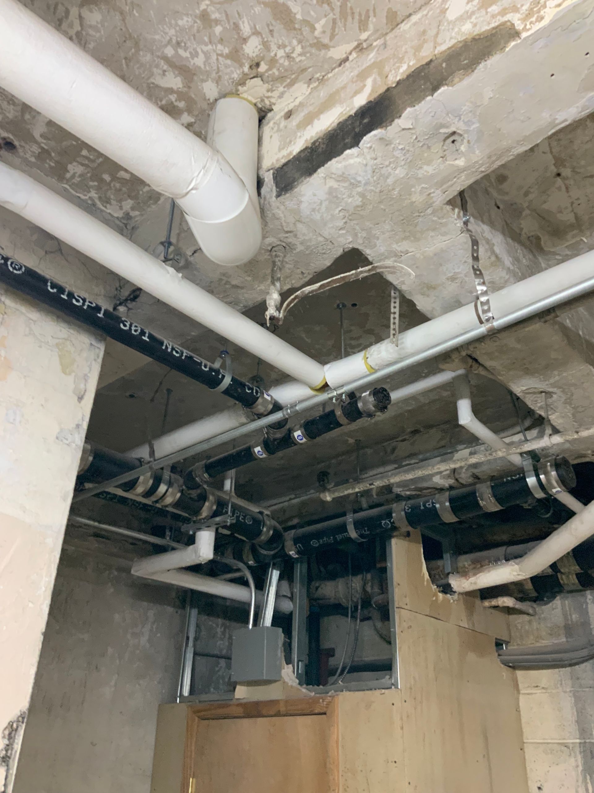 A bunch of pipes are hanging from the ceiling of a building.