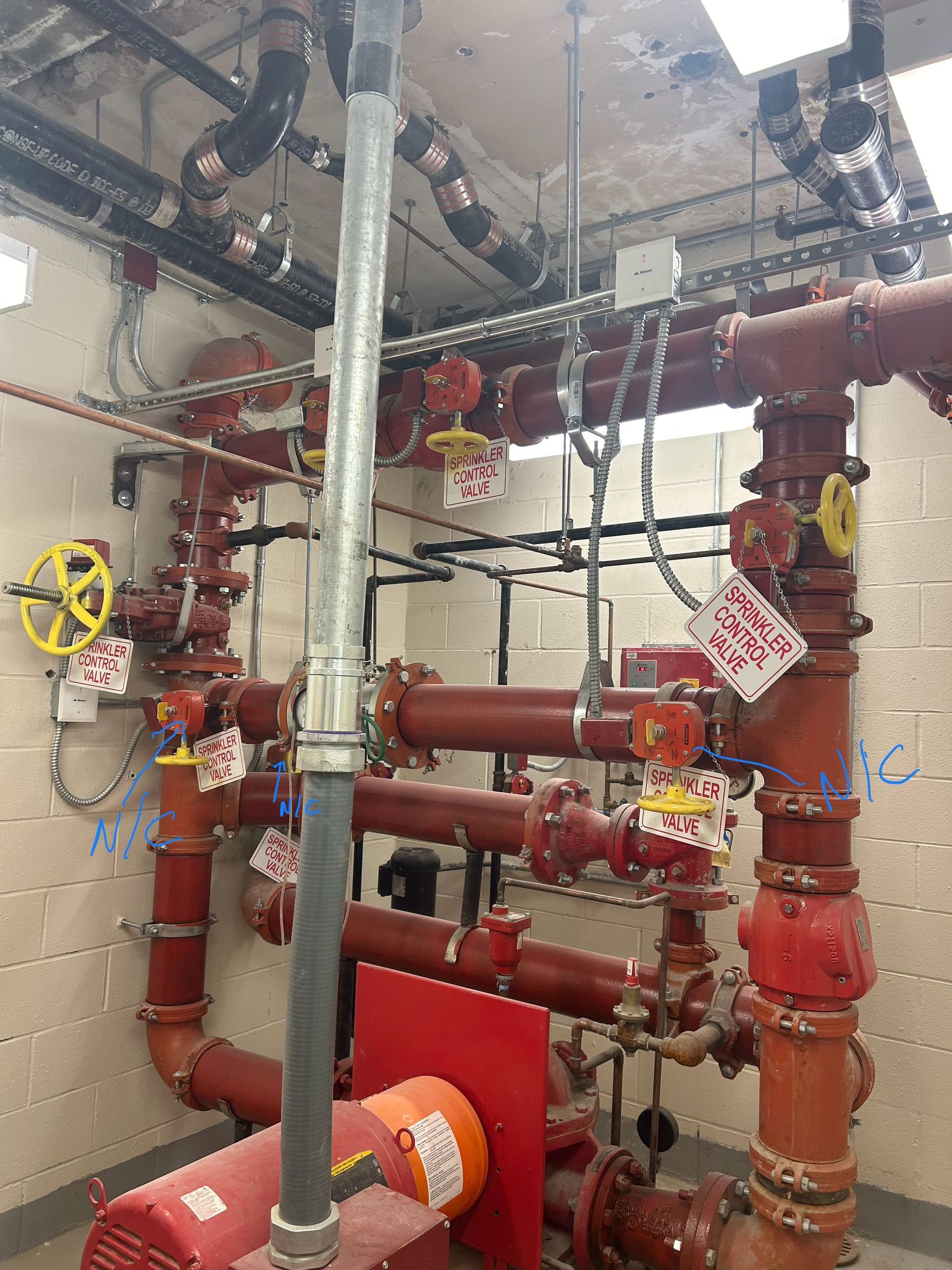 A man is kneeling down in the grass working on a lawn.