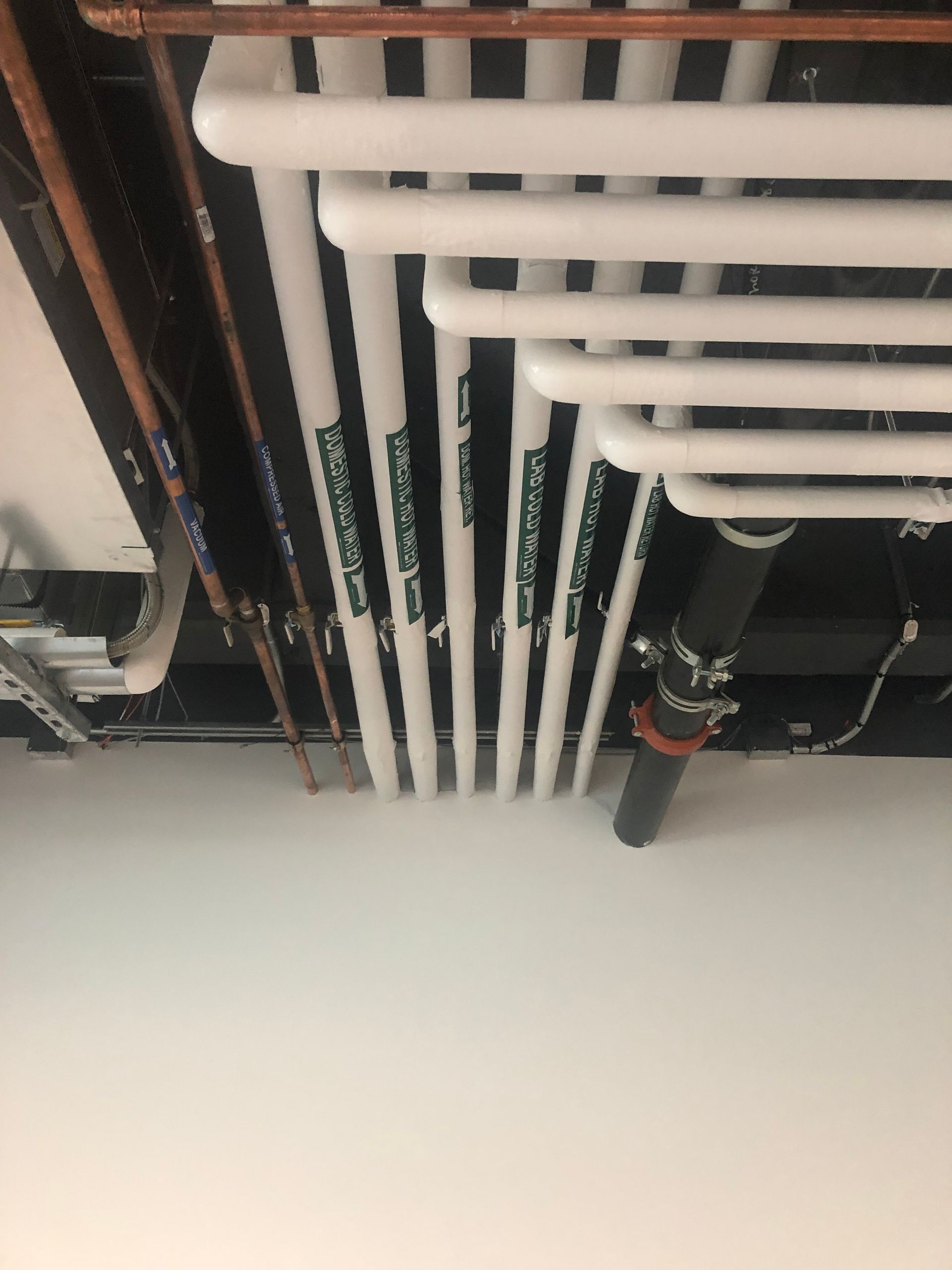 A bunch of pipes are hanging from the ceiling