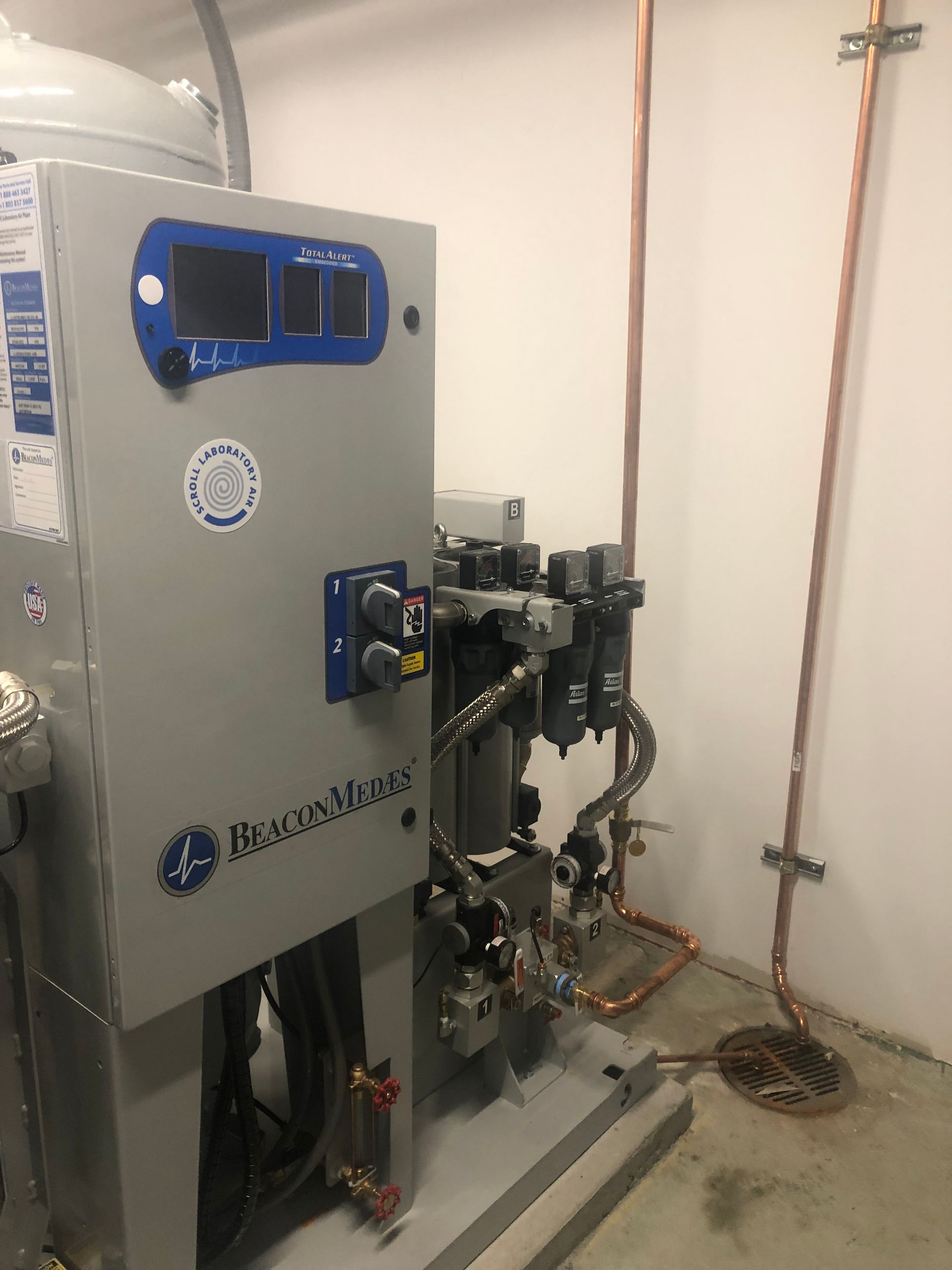 A machine is sitting in a room with copper pipes.