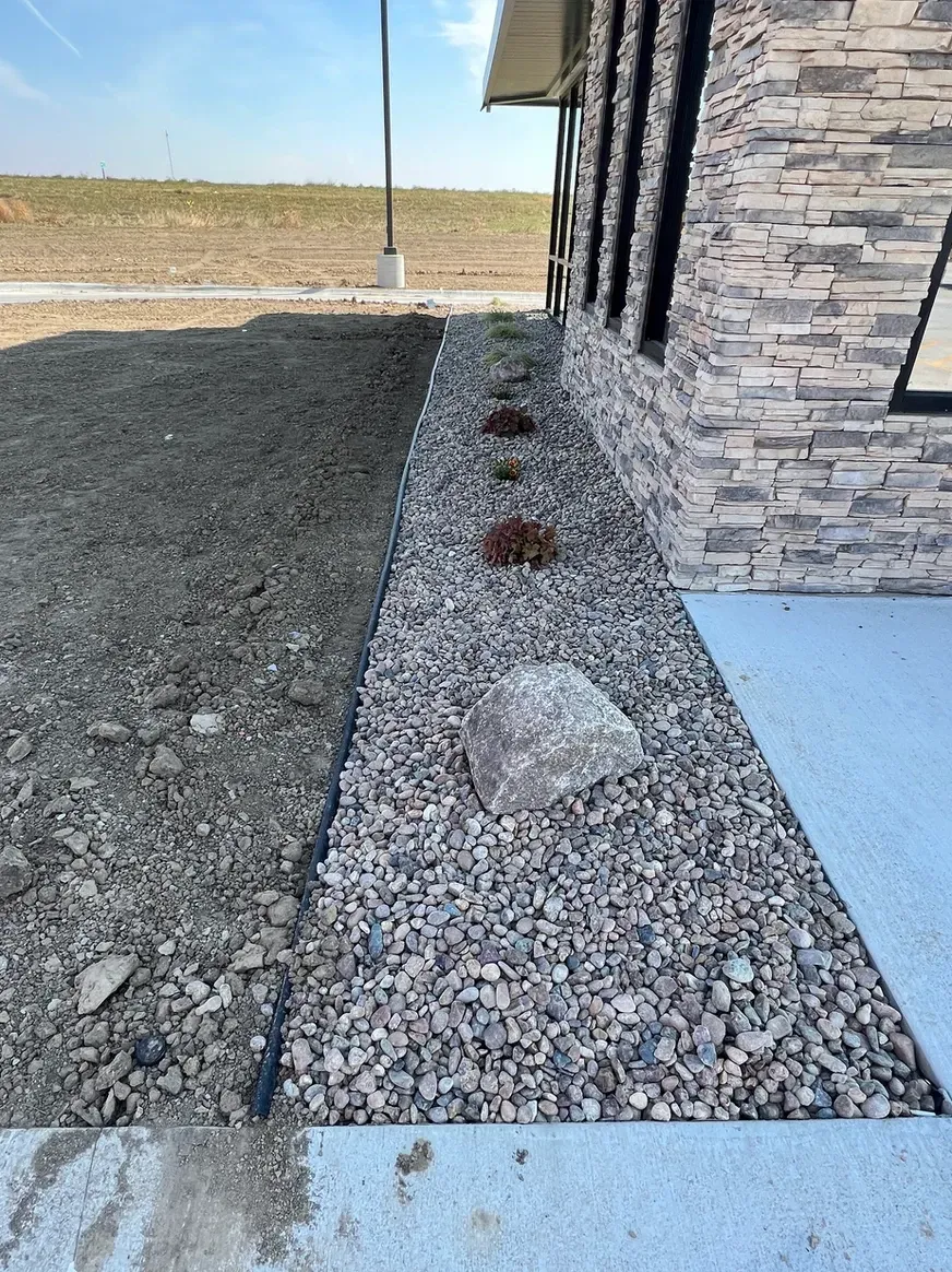 A Sidewalk with Rocks and Plants in Front of A House — Exeter, NE — Axline Landscaping & Trees