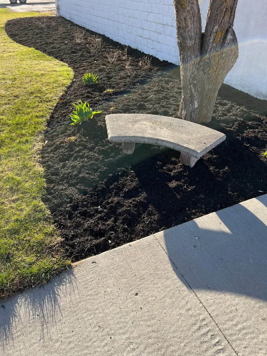 A Concrete Bench Is Sitting Next to A Tree in A Garden — Exeter, NE — Axline Landscaping & Trees