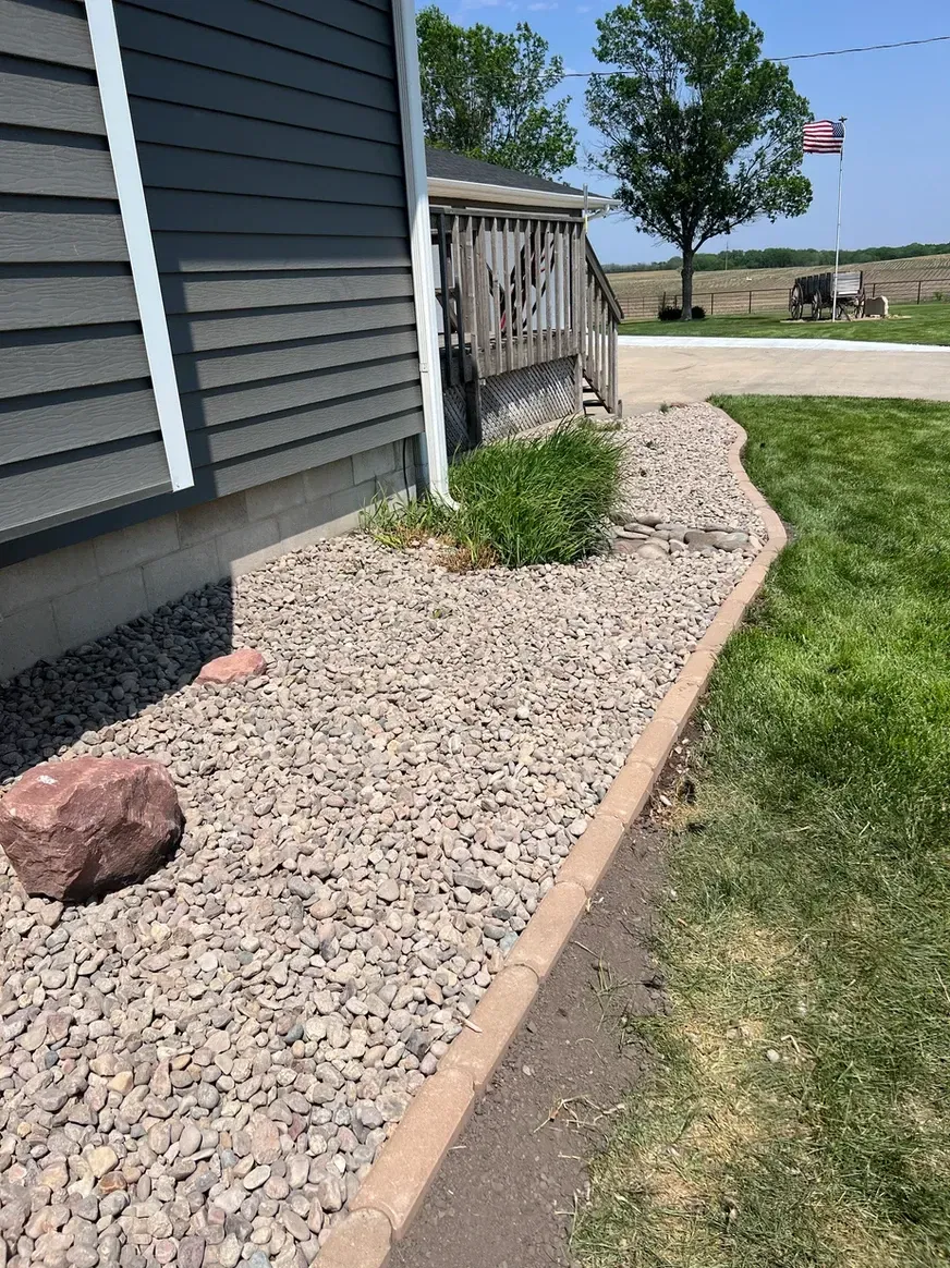 A Sidewalk with Gravel and Grass Next to A House — Exeter, NE — Axline Landscaping & Trees