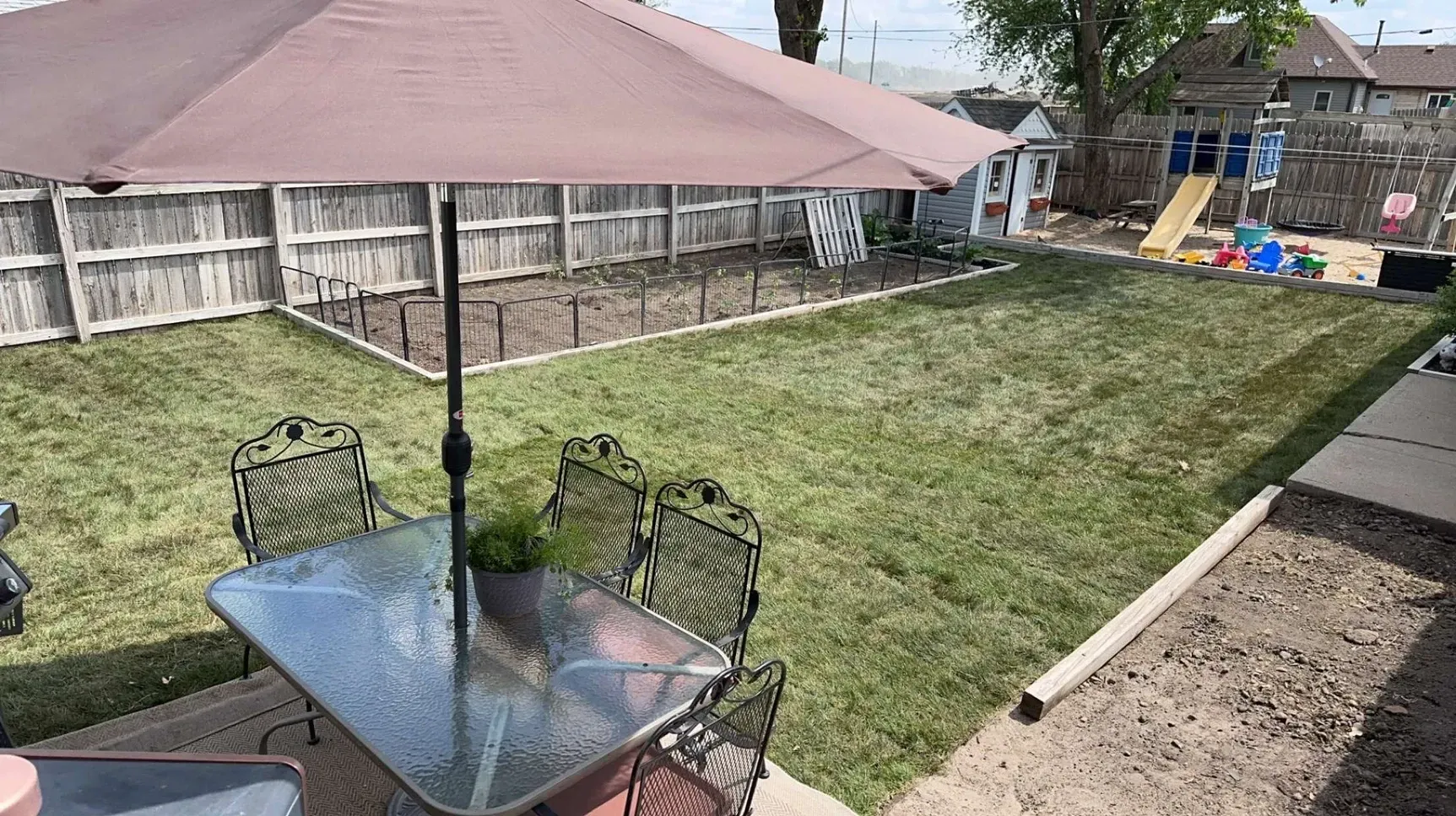 Table and Chairs Under an Umbrella in The Backyard — Exeter, NE — Axline Landscaping & Trees
