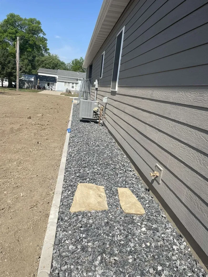 A Sidewalk Leading to A House with Gravel in Front of It — Exeter, NE — Axline Landscaping & Trees