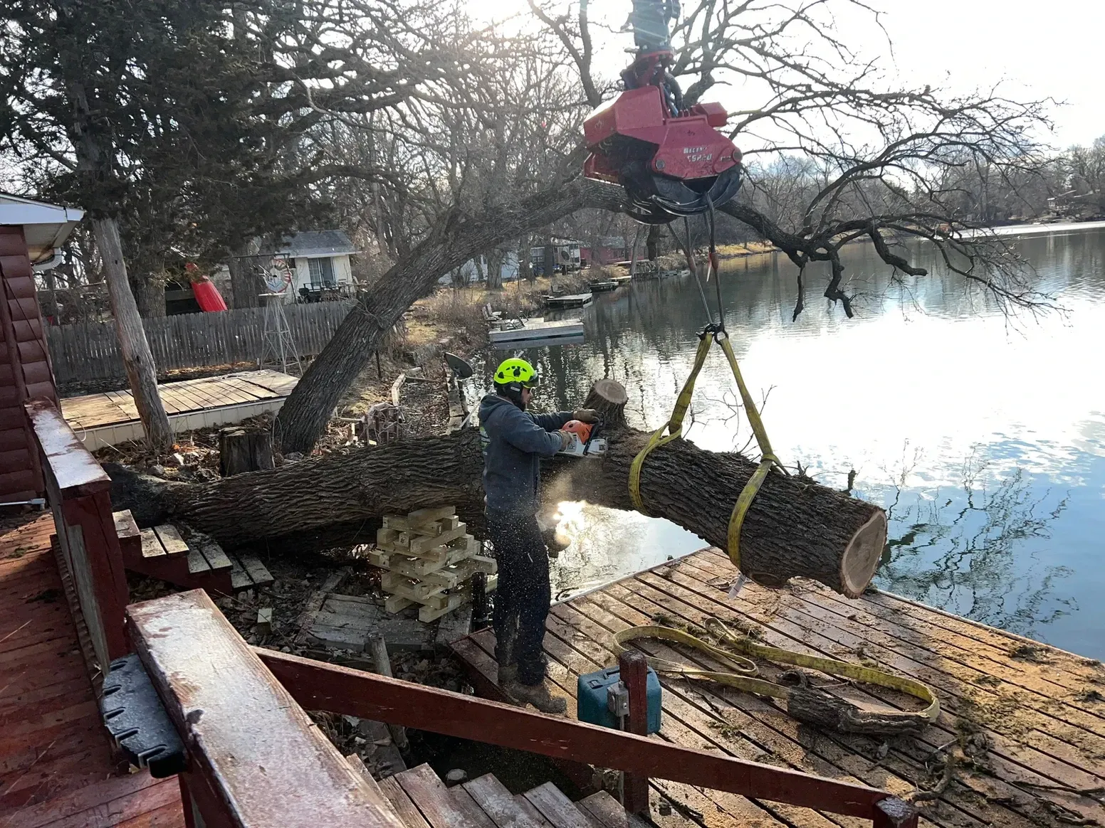 Man Is Cutting Down a Tree with A Chainsaw — Exeter, NE — Axline Landscaping & Trees
