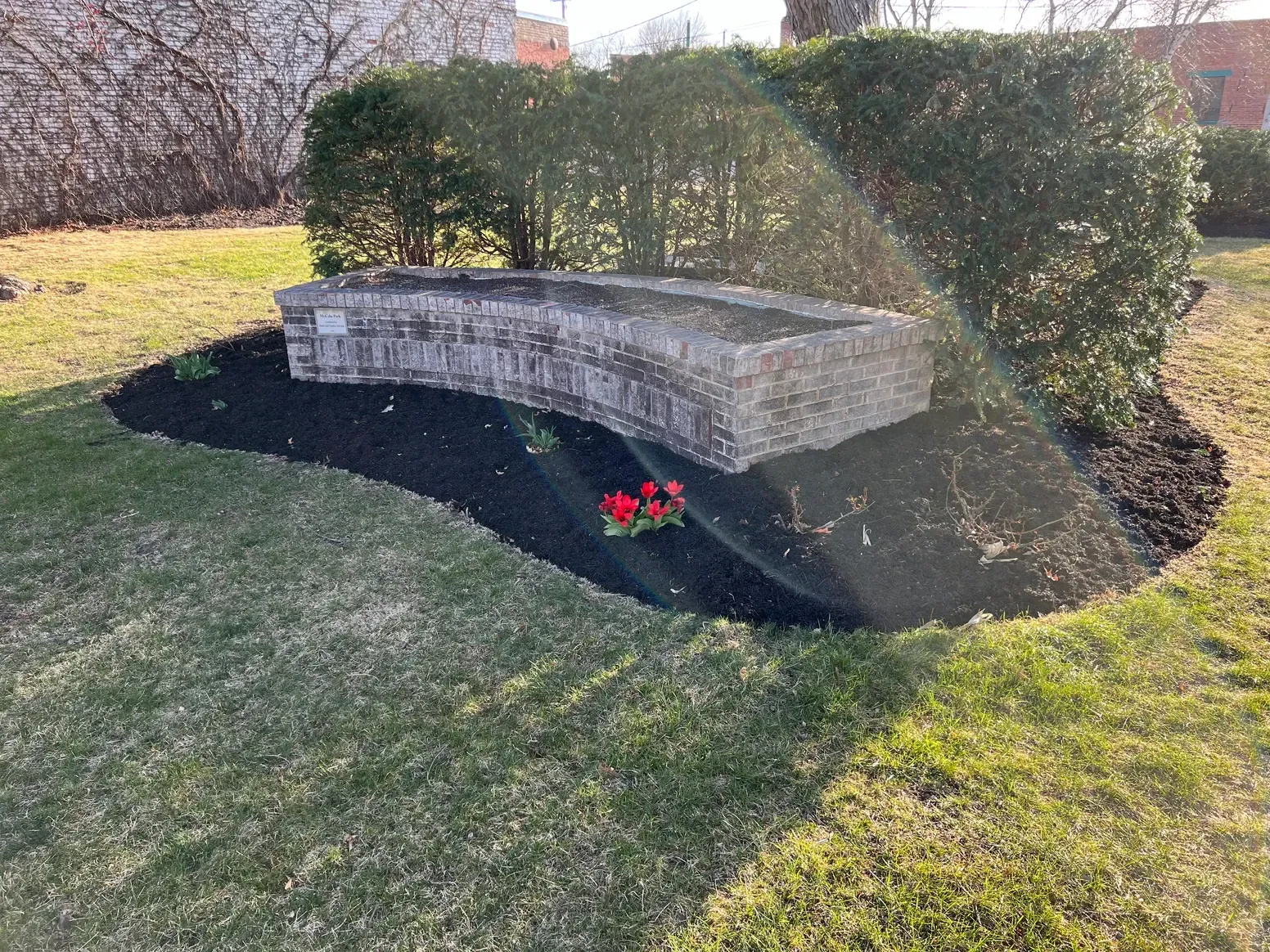 A Stone Wall Is Sitting in The Middle of A Lush Green Field — Exeter, NE — Axline Landscaping & Trees
