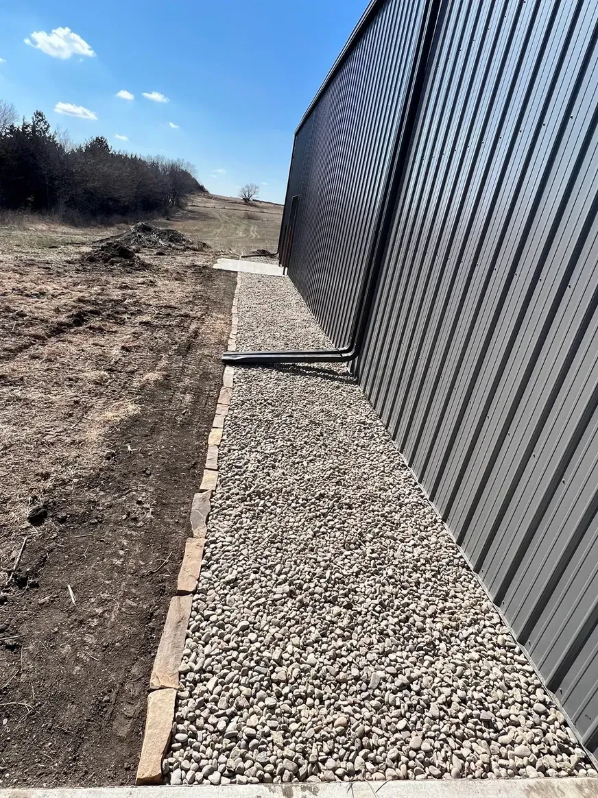 A Gravel Path Leads To A Chain Link Fence — Exeter, NE — Axline Landscaping & Trees